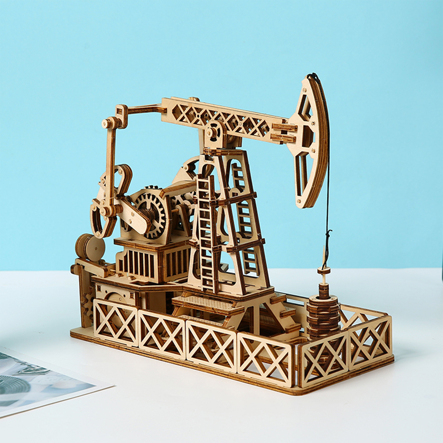 Un modello in legno di una pompa petrolifera con sfondo blu.