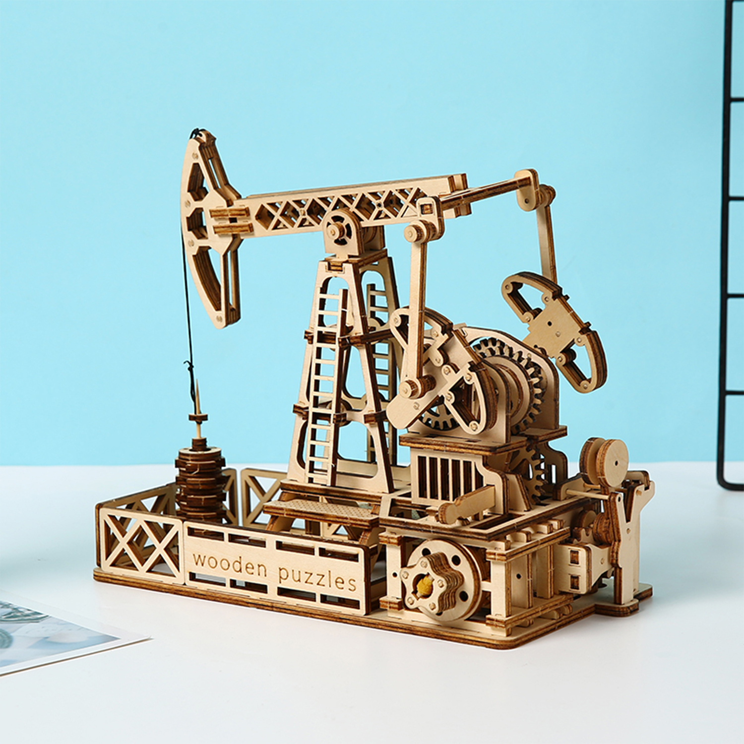 Un modello in legno di una pompa petrolifera con ingranaggi e struttura intricati.