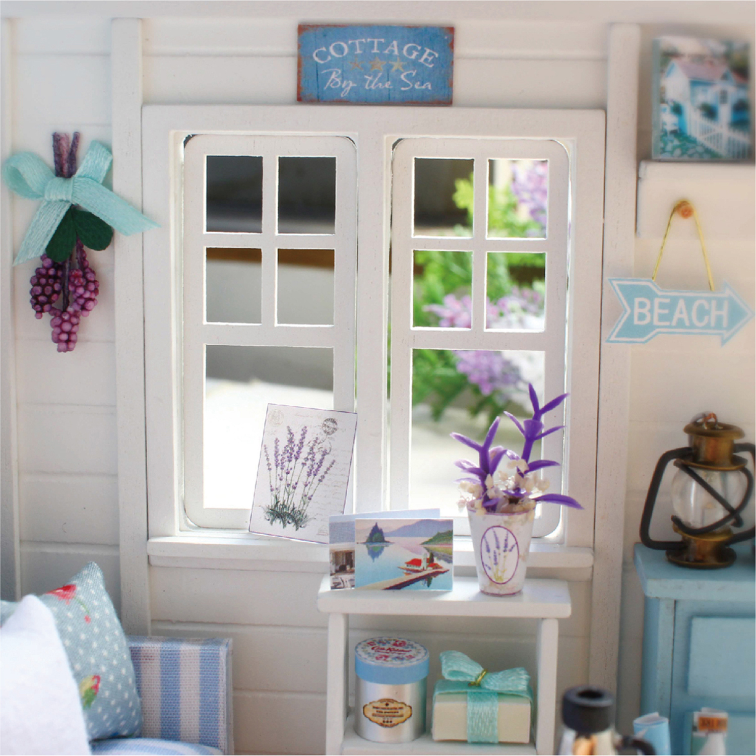Decorazioni in miniatura di cottage con finestra, insegne e fiori.