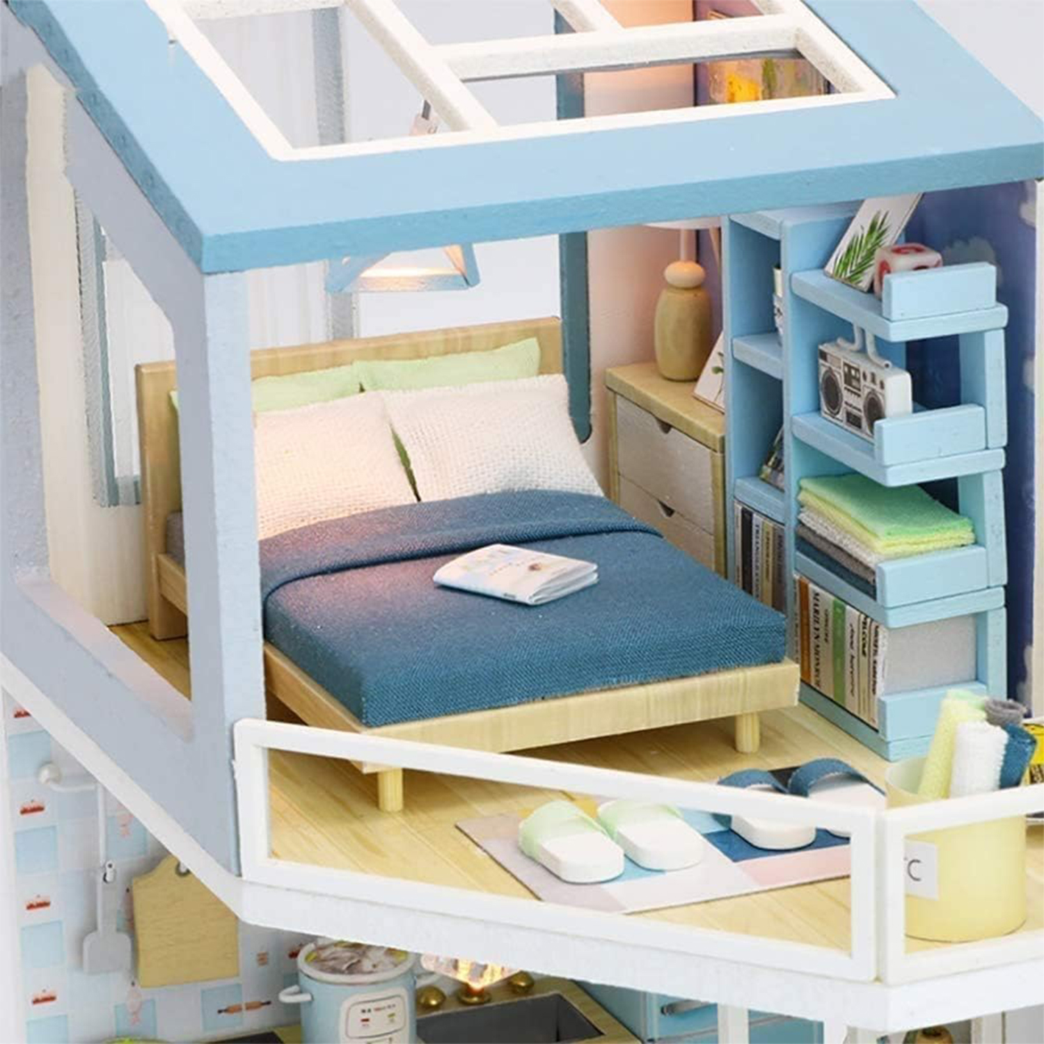 Camera in miniatura con letto blu, libreria e piccola radio.
