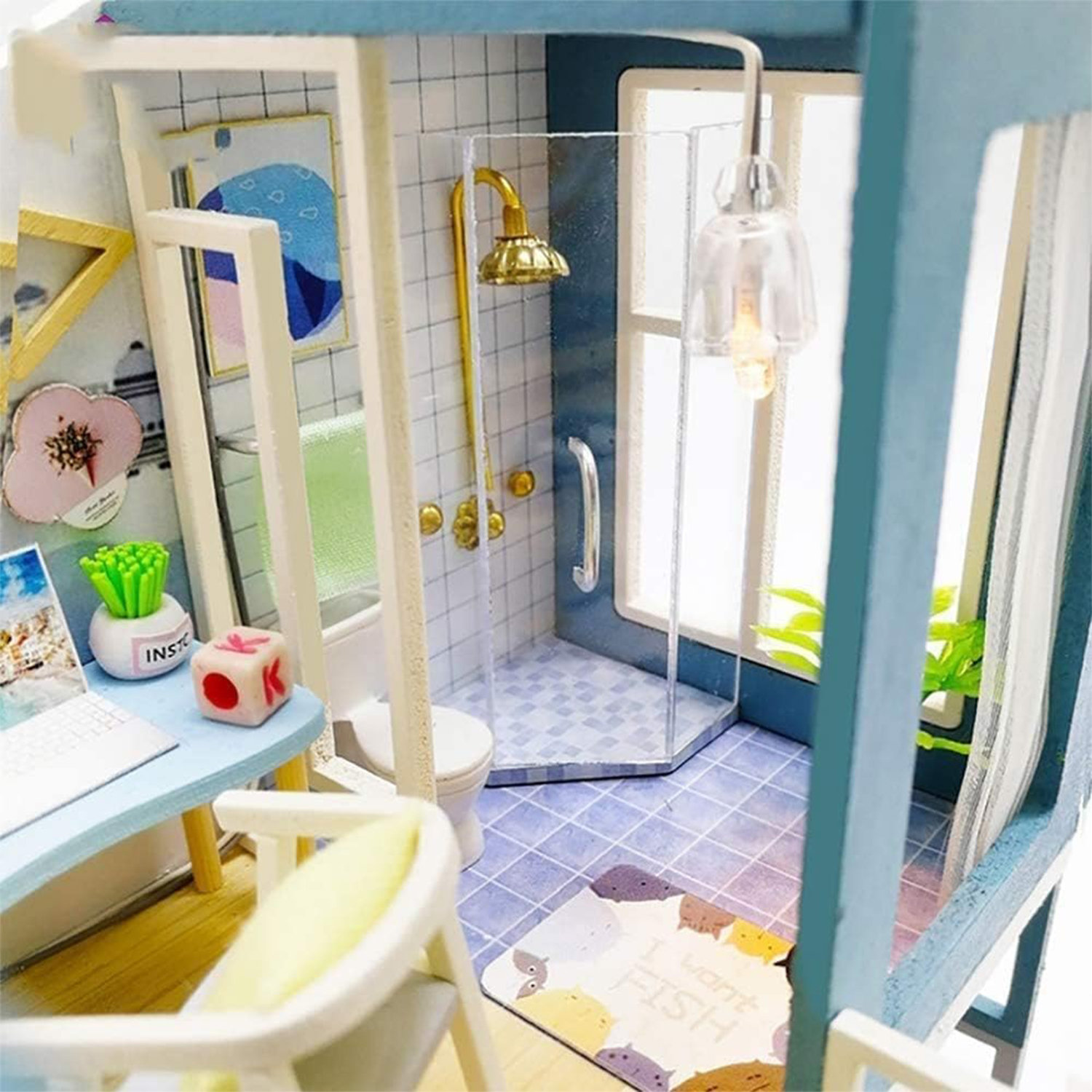 Bagno in miniatura con doccia, WC, scrivania e lampada.
