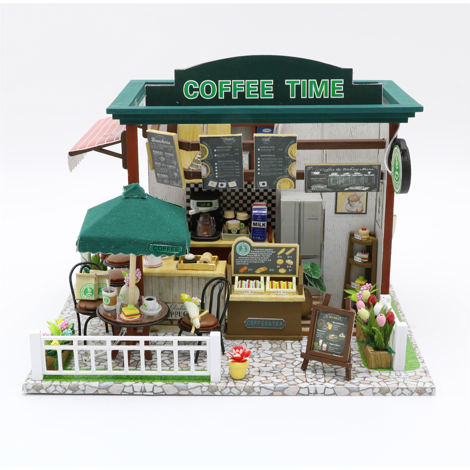 Un negozio di caffè in miniatura con tavoli, sedie, menu e fiori. Presenta una macchina da caffè e un frigo.