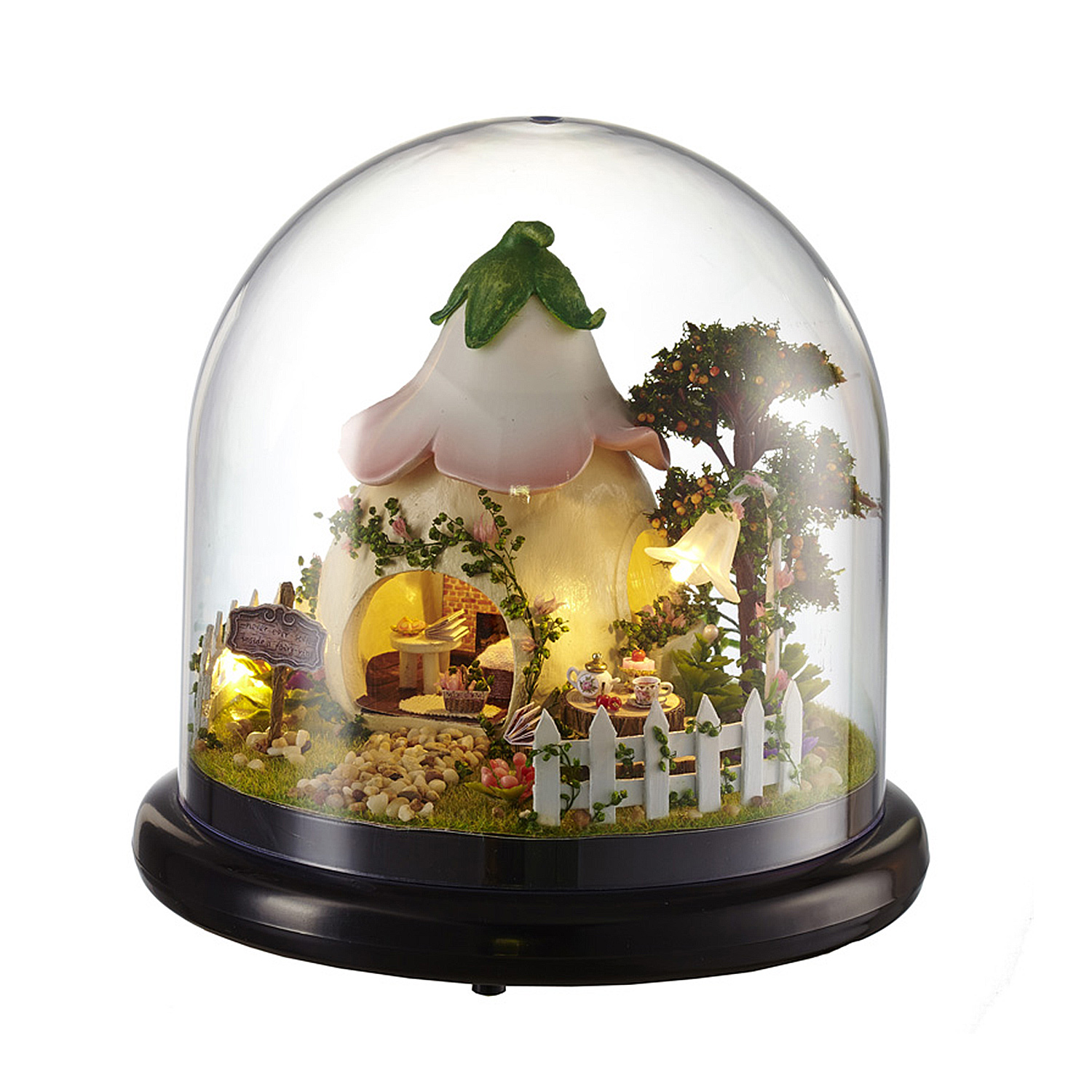 Casa in miniatura all'interno di una campana di vetro con fiori, alberi e mobili.