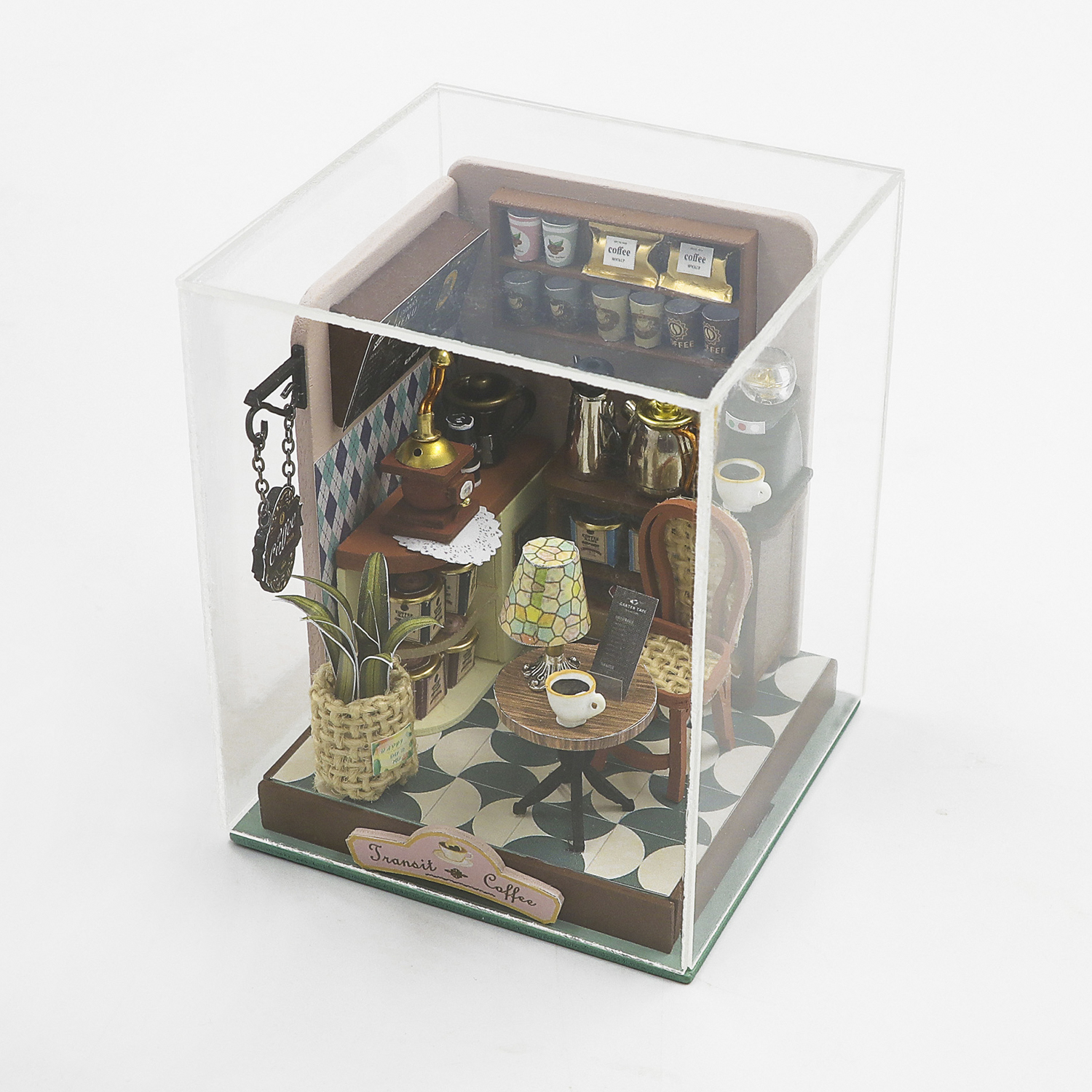 Diorama caffetteria in miniatura con macinacaffè, tavoli, sedie e articoli da caffè.