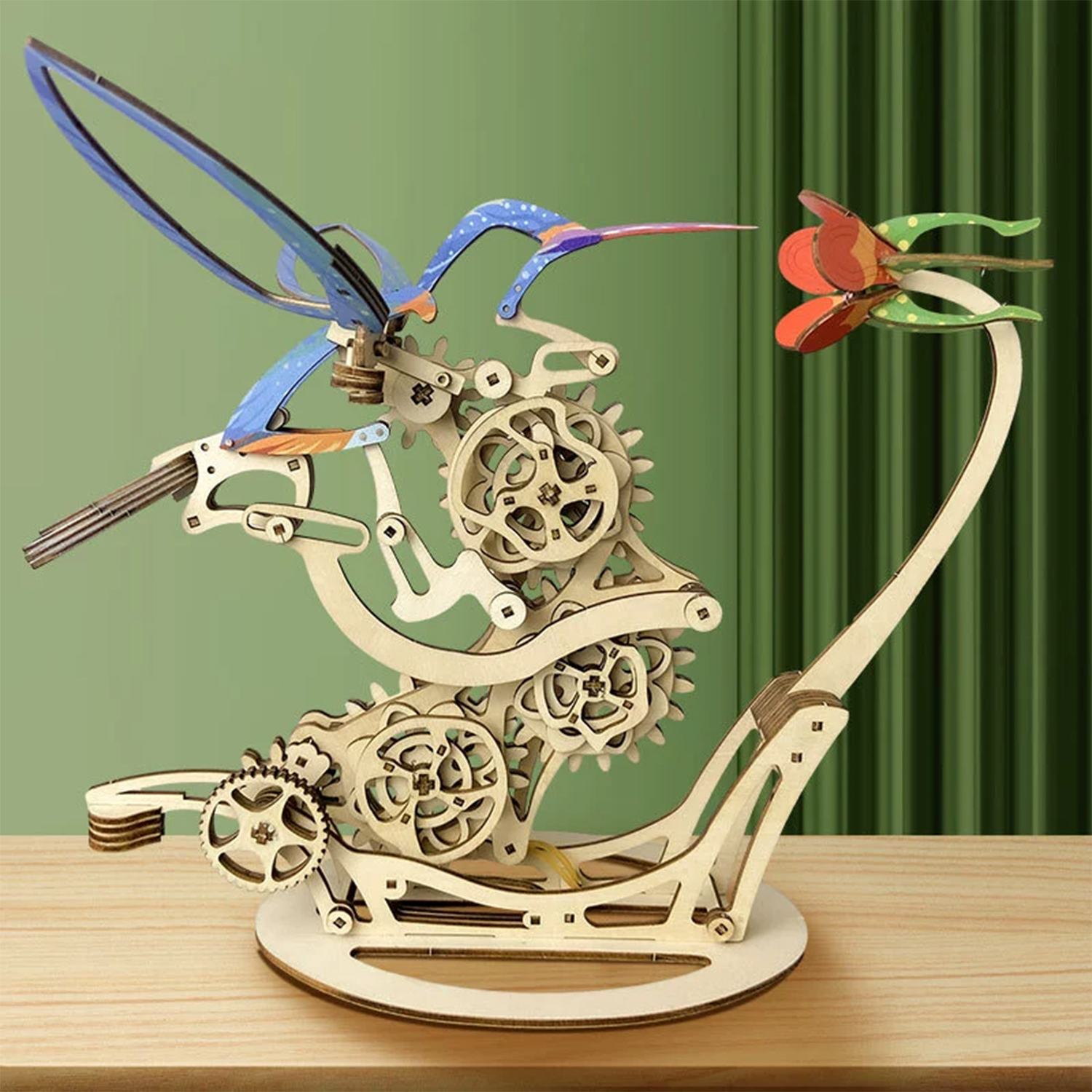 Modello in legno di un colibrì che si avvicina a un fiore, con ingranaggi.