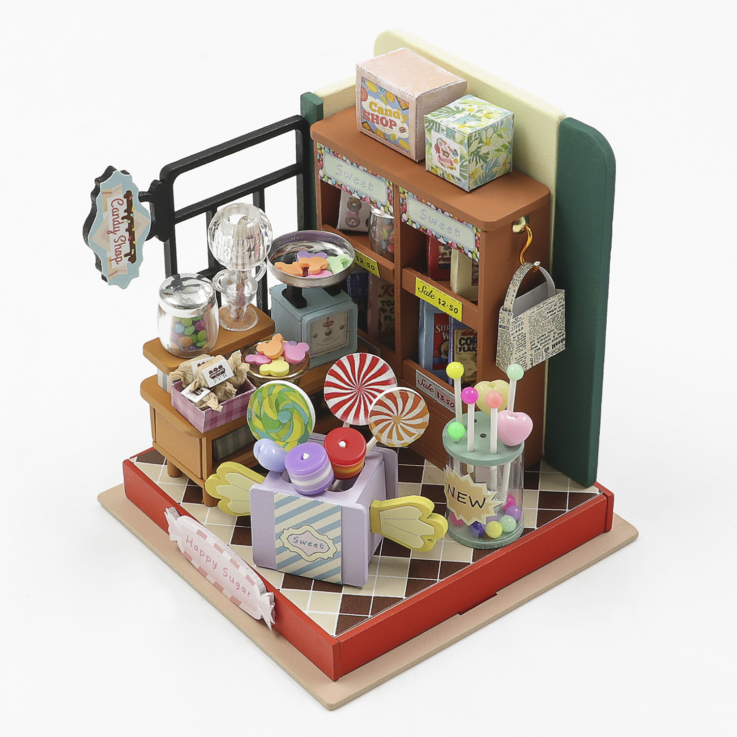Negozio di caramelle in miniatura con bilancia, caramelle, lecca-lecca e cartellini.