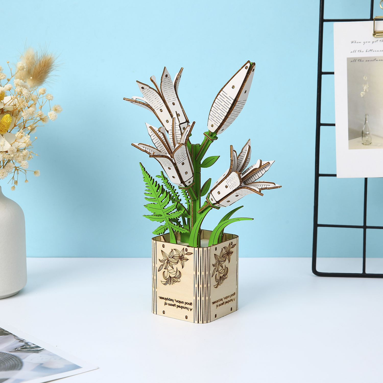 Modello in legno di giglio bianco in vaso con felci e fiori secchi.