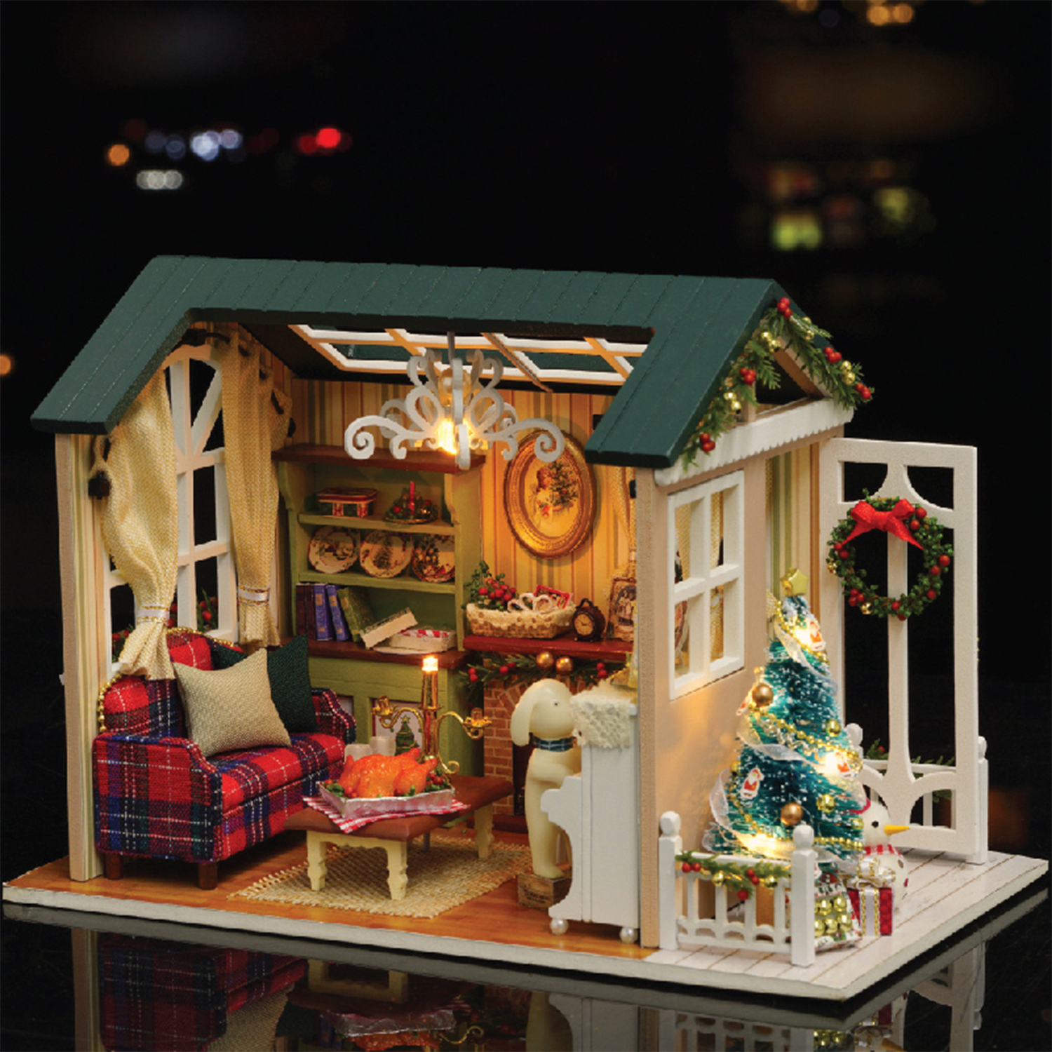 Casa delle bambole decorata per Natale con camino, divano e albero.
