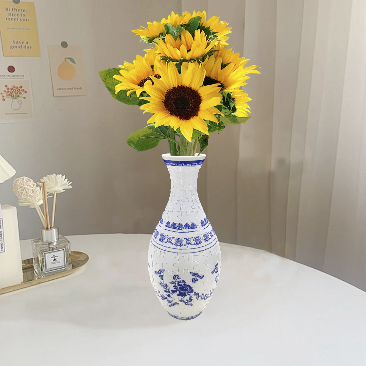 Un vaso di girasoli è su un tavolo vicino a un diffusore e una candela profumata.