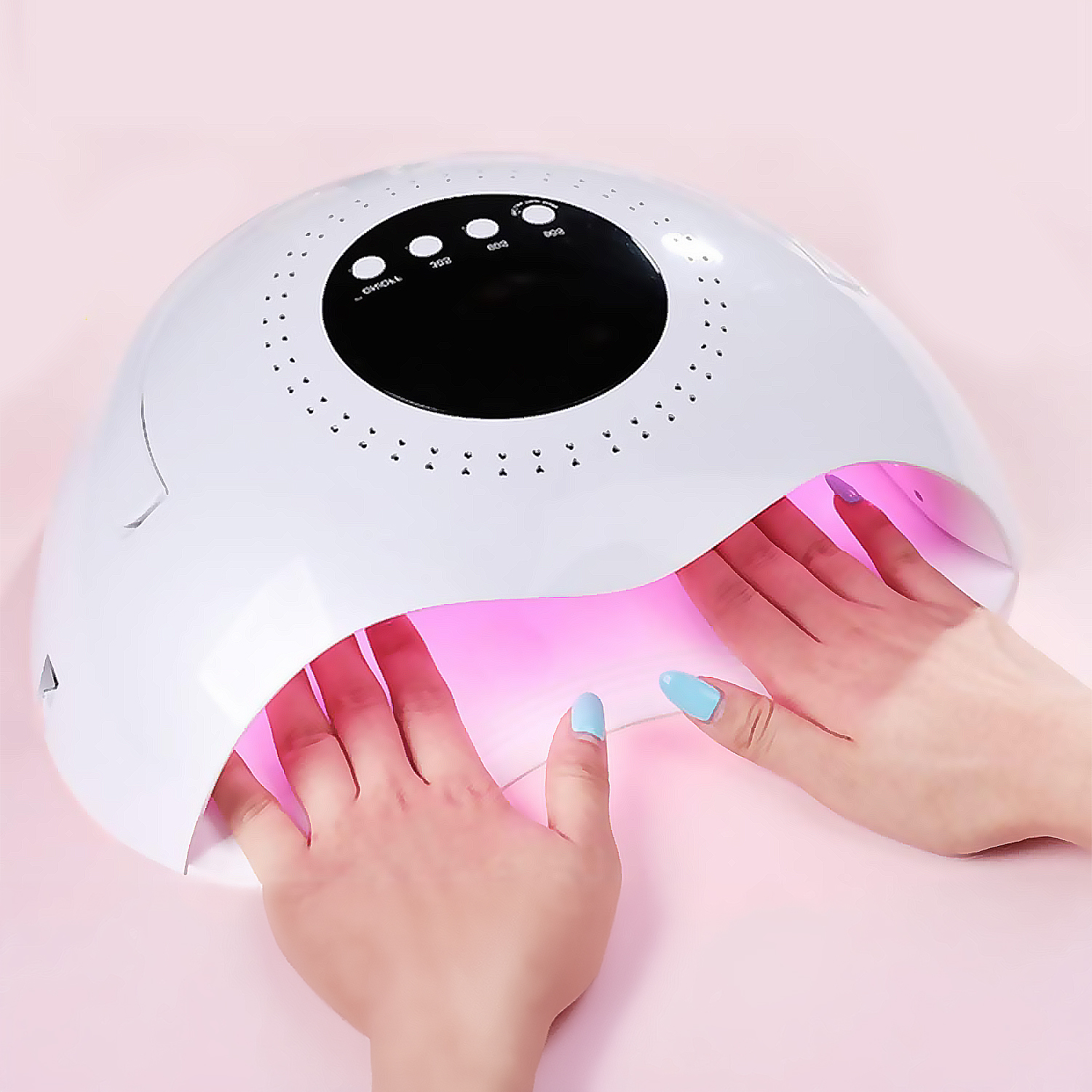 Una lámpara UV blanca seca uñas con esmalte azul y morado.