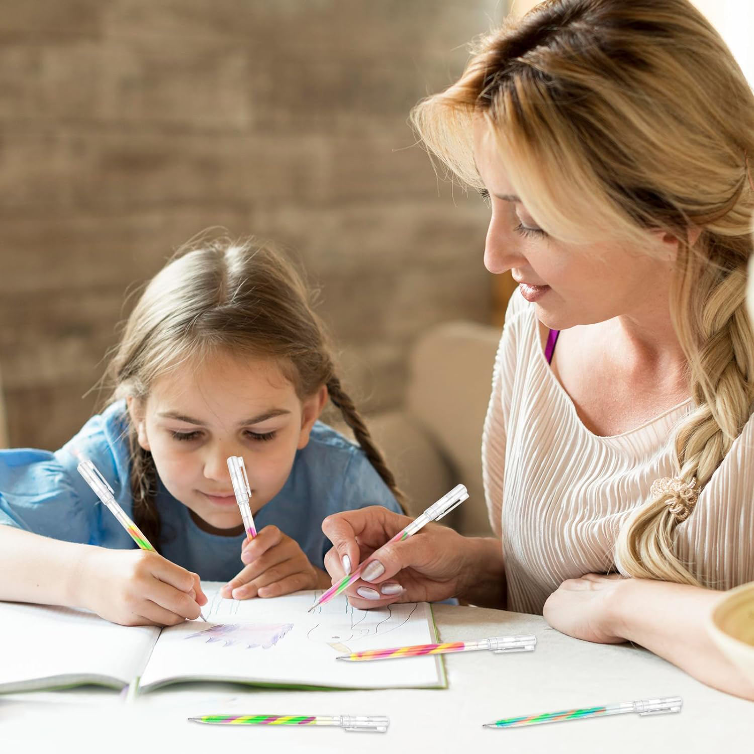 Madre e hija dibujan con bolígrafos de colores en un cuaderno.