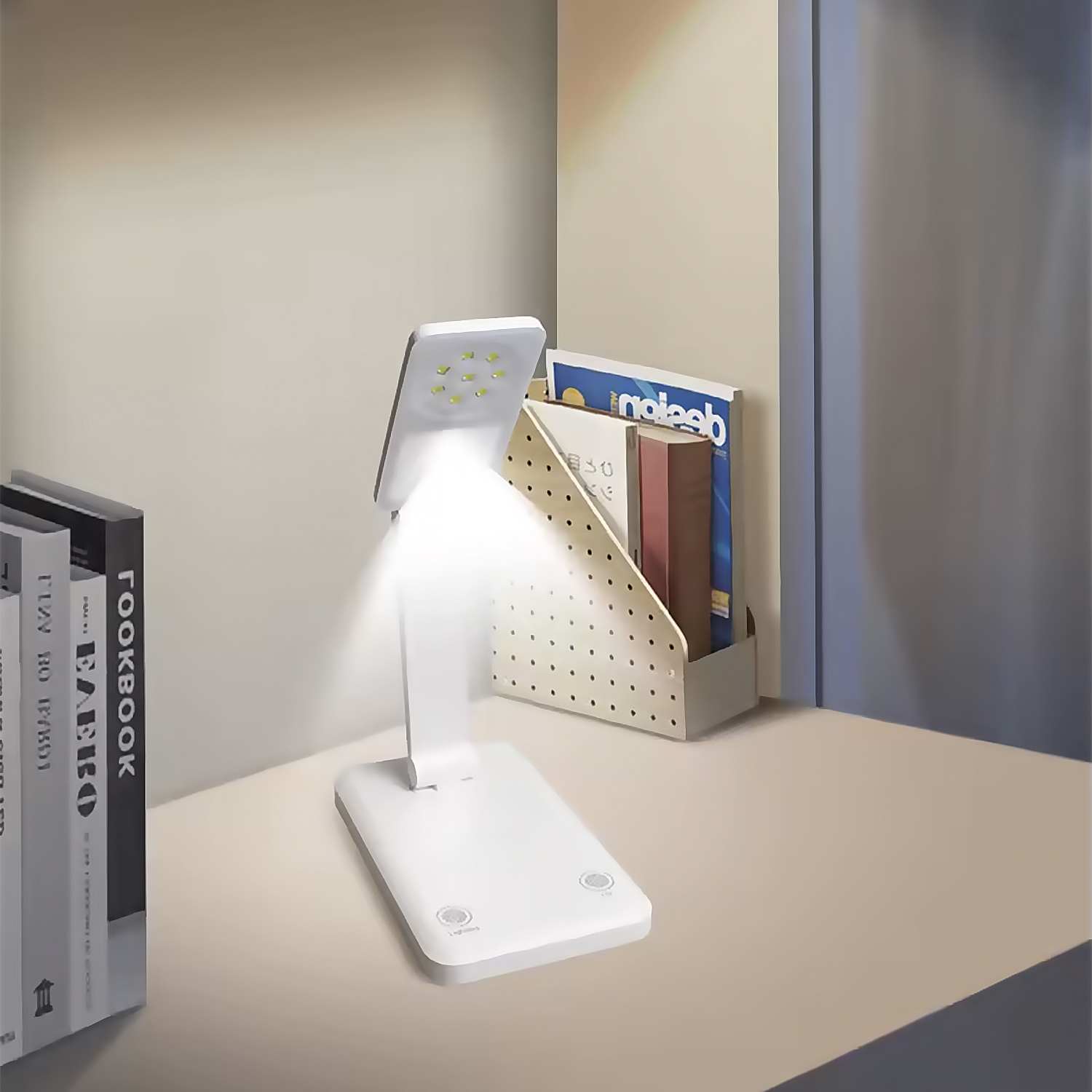 Un escritorio blanco con lámpara, libros y revistas.