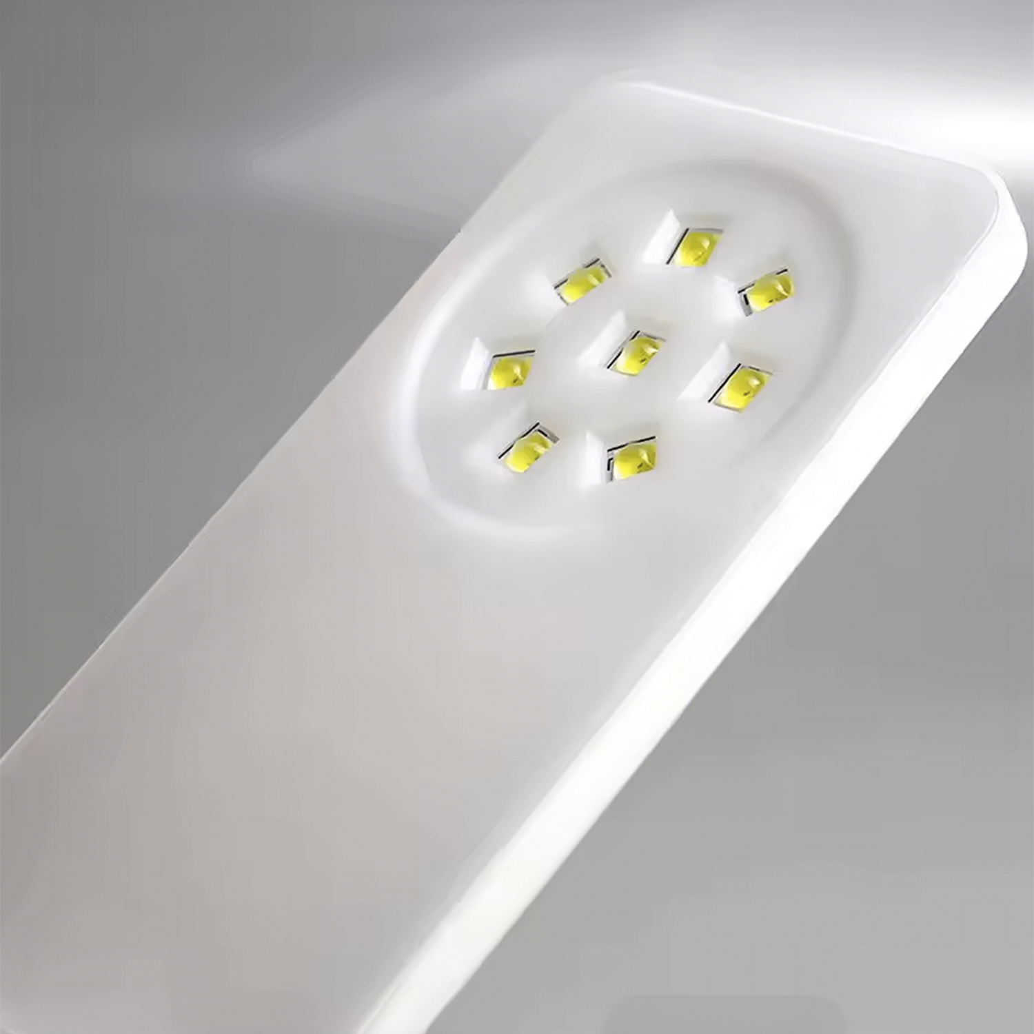 Lámpara blanca con varios LEDs amarillos dispuestos en círculo.