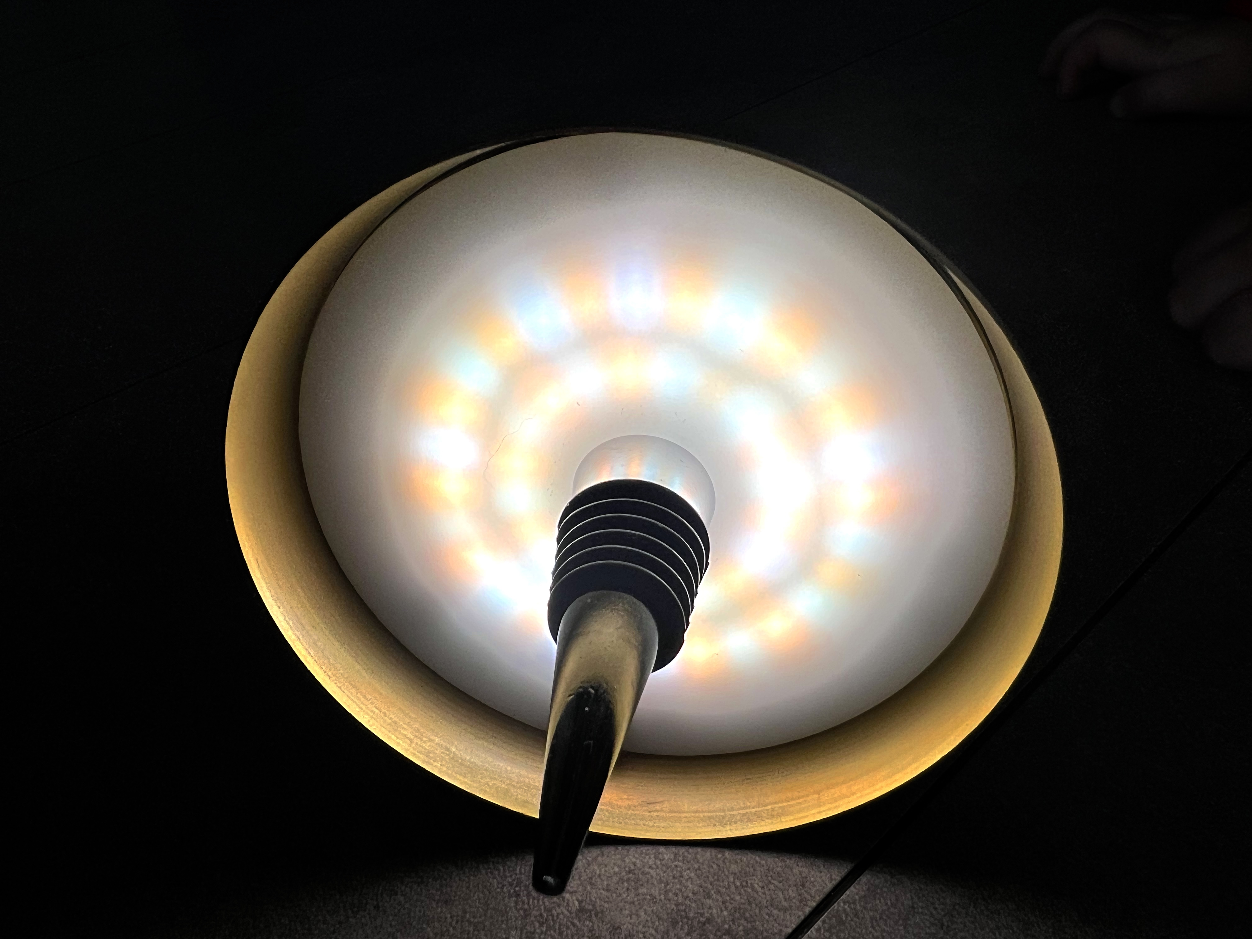 Eine Lampe mit bunten LEDs leuchtet nach oben, mit einem goldenen Rand.