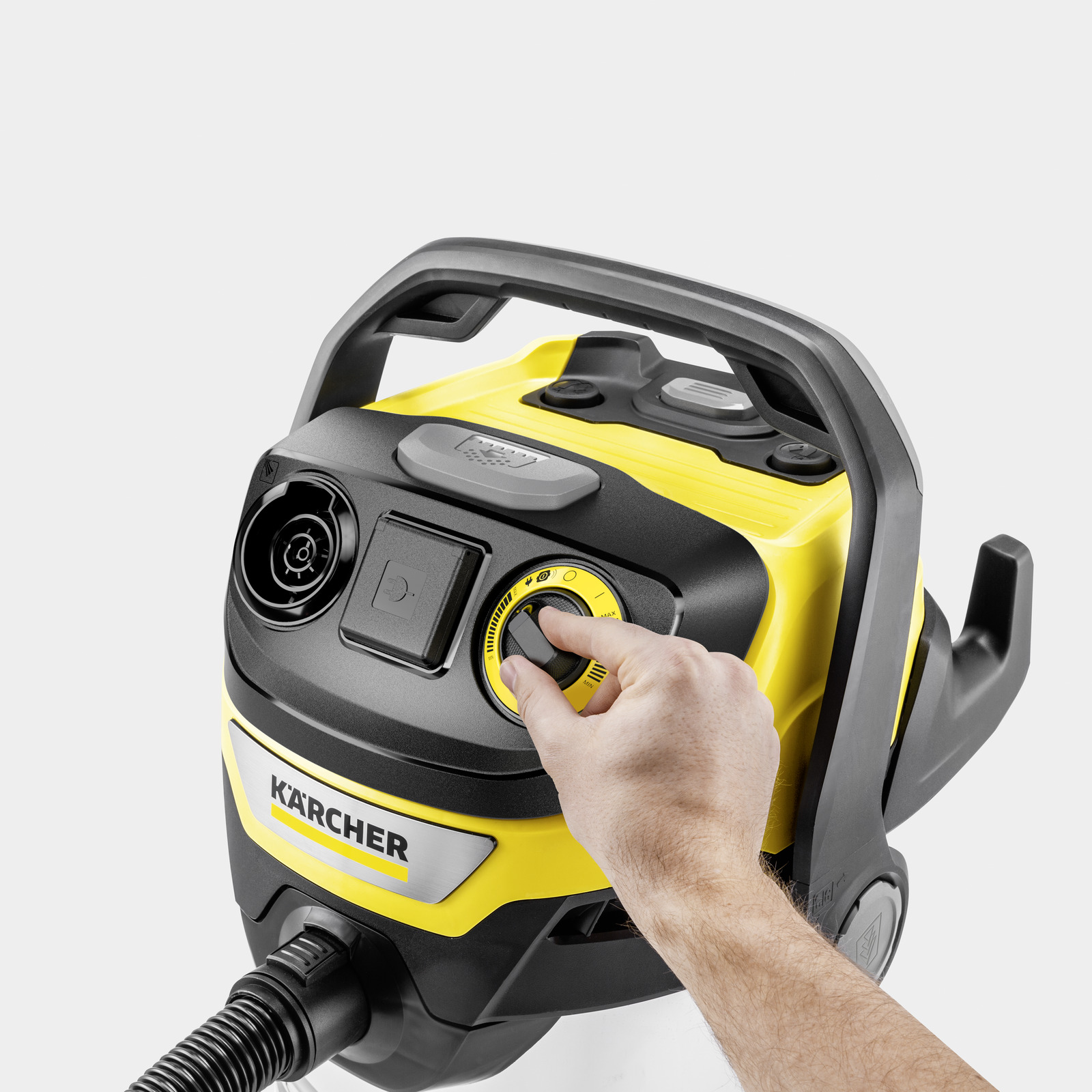 Mano che gira quadrante giallo su aspirapolvere Kärcher con manico nero.