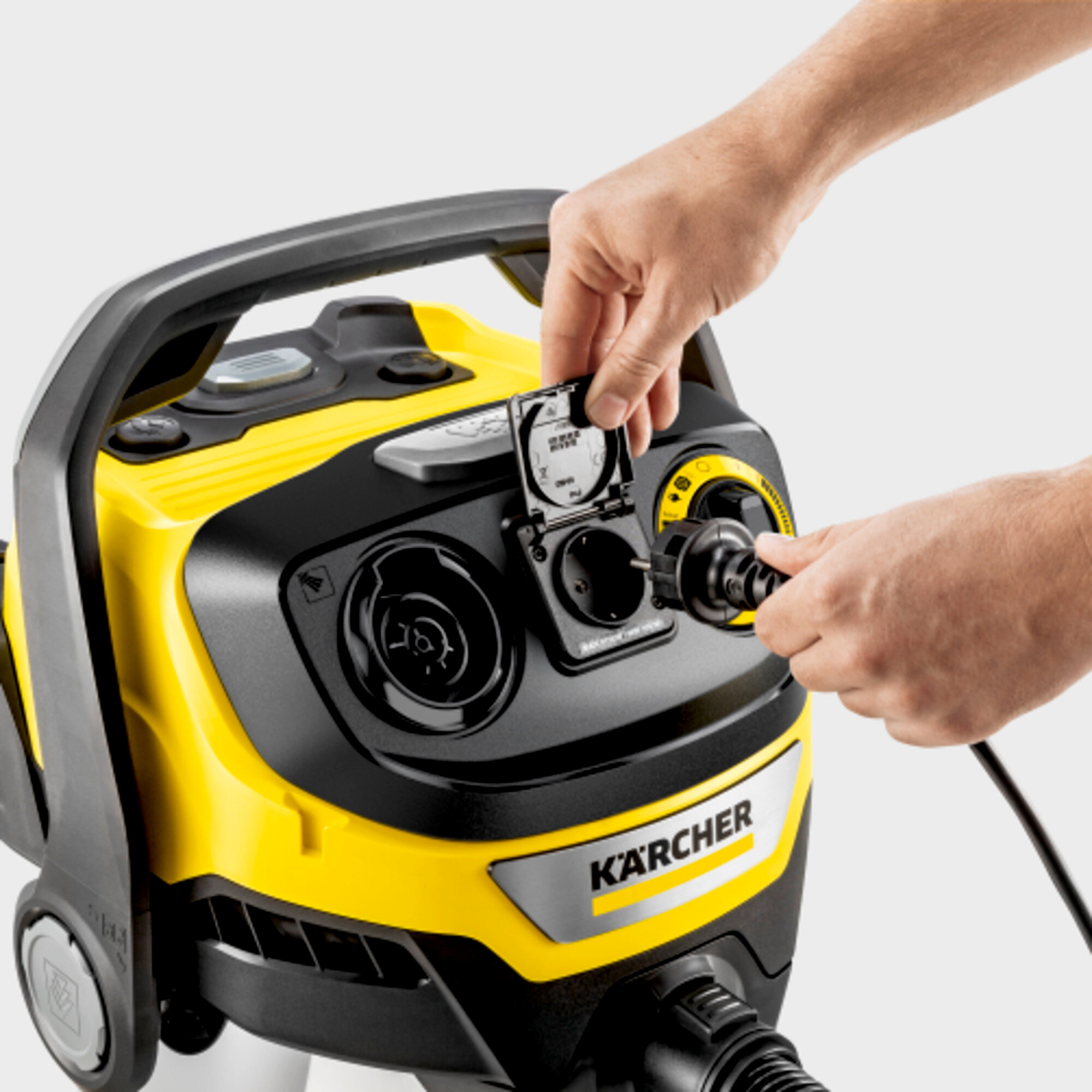 Uomo inserisce cavo in dispositivo Karcher giallo con manico nero.