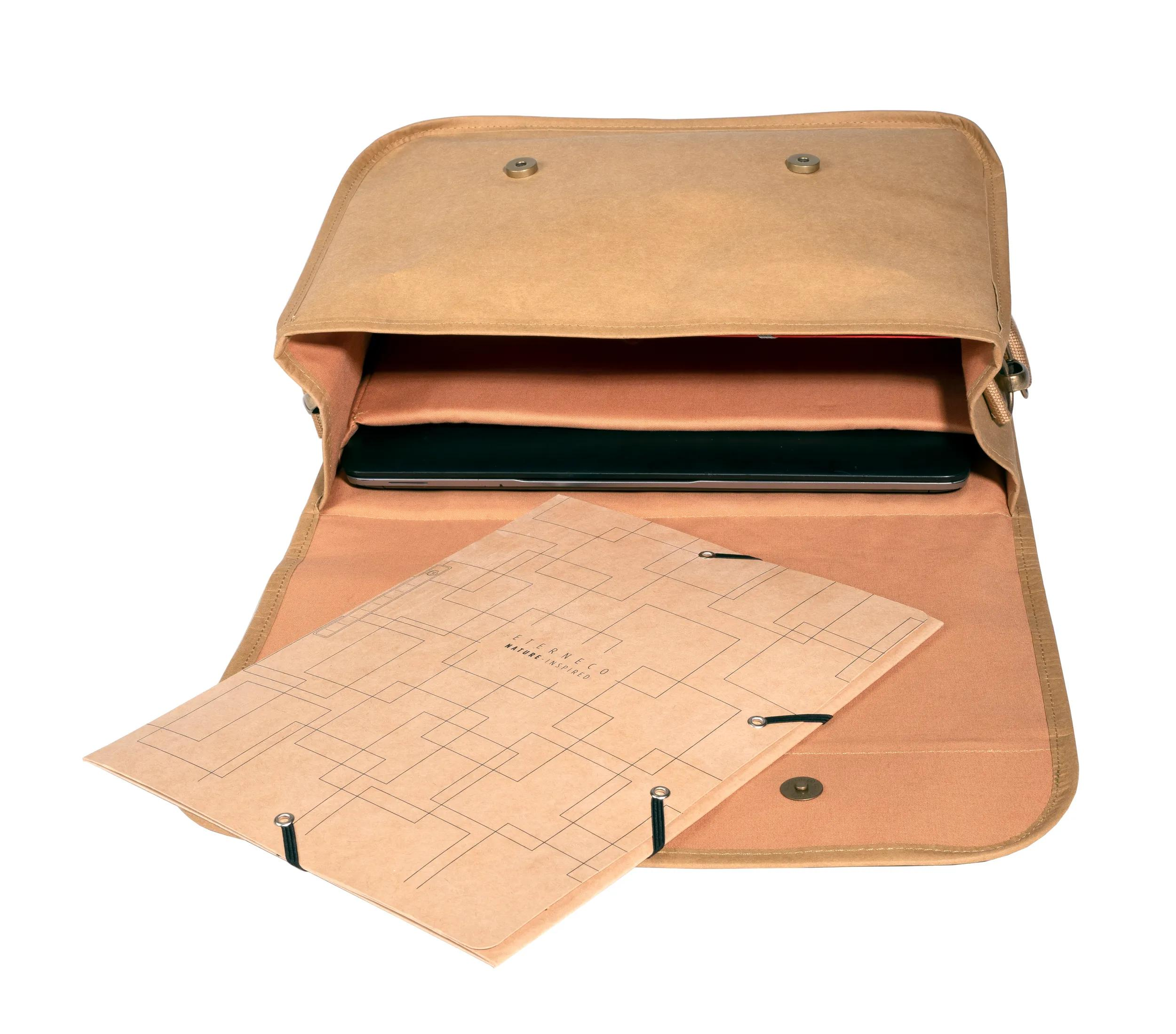 Una bolsa beige con un portátil y una carpeta dentro.