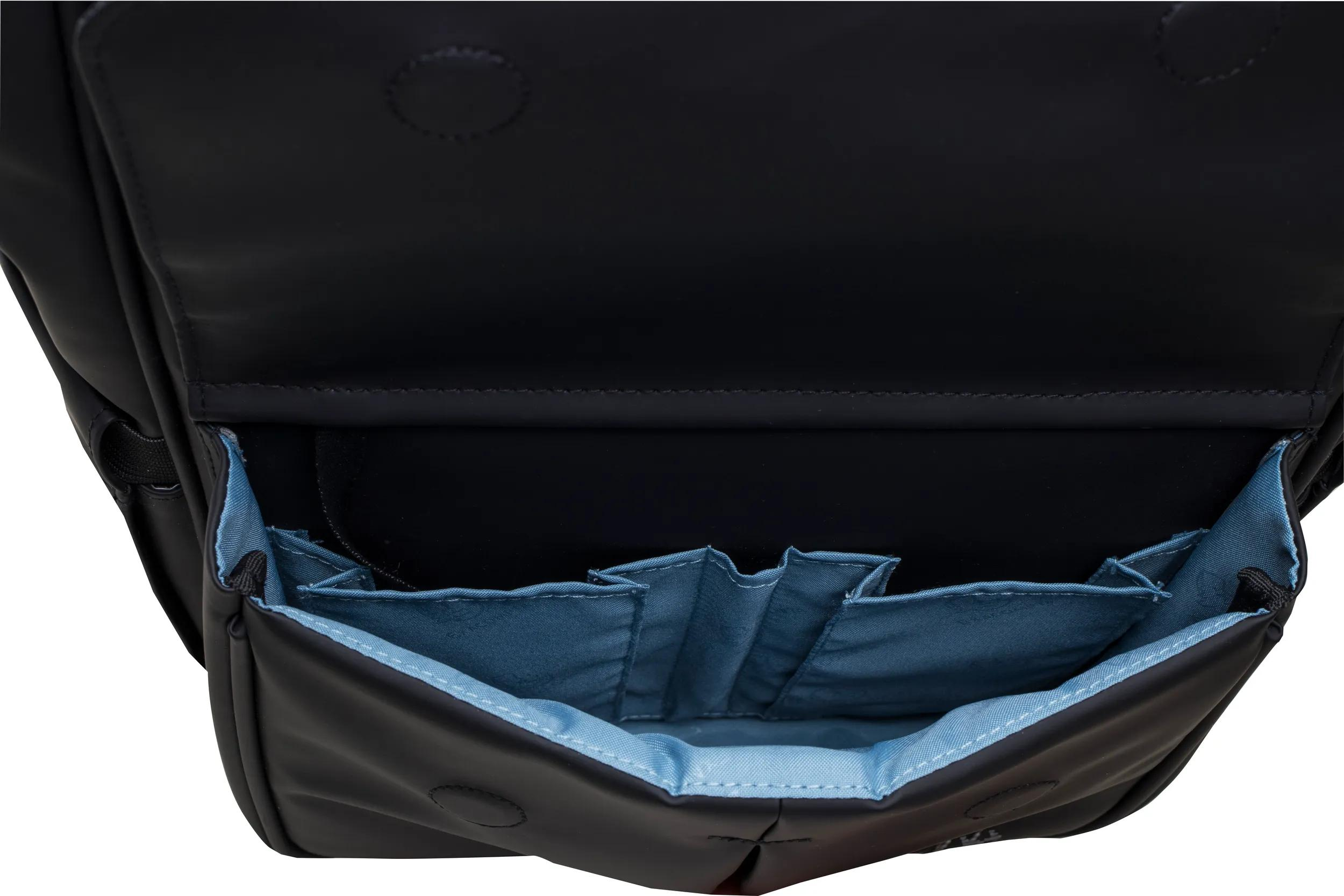 Bolso negro con compartimentos y costuras forrados de azul.