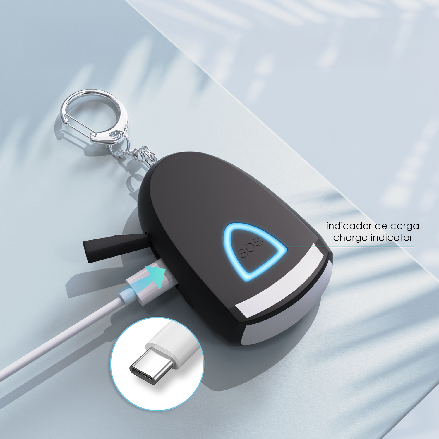 Dispositivo SOS negro con llavero, carga por USB-C. Indicador LED azul.