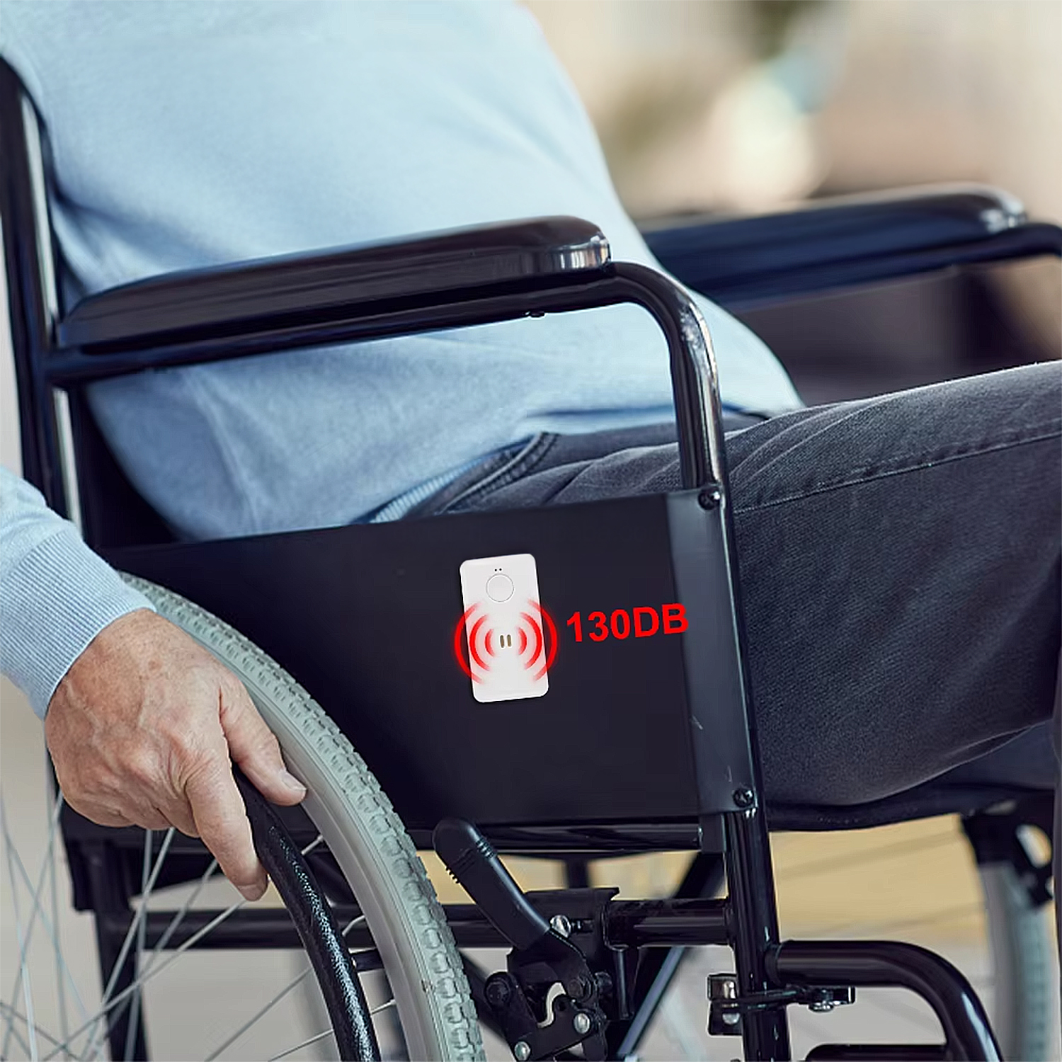 Un hombre en silla de ruedas con un dispositivo de alarma de 130dB al lado.