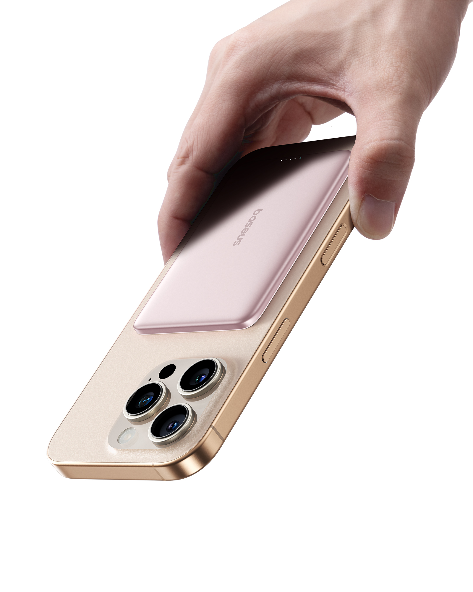 Una mano tiene uno smartphone dorato con tre fotocamere. Una power bank rosa è attaccata.