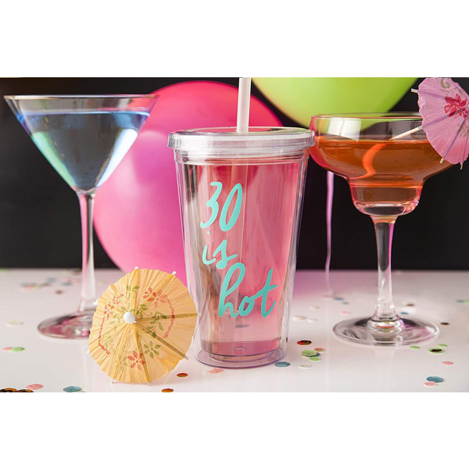 Un bicchiere trasparente con liquido rosa, che dice "30 is hot".