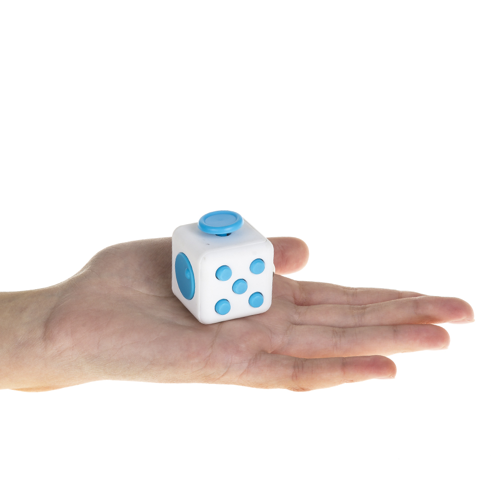 Una mano sostiene un cubo de juguete blanco con botones azules. Un lado tiene un botón, otro tiene cinco puntos.