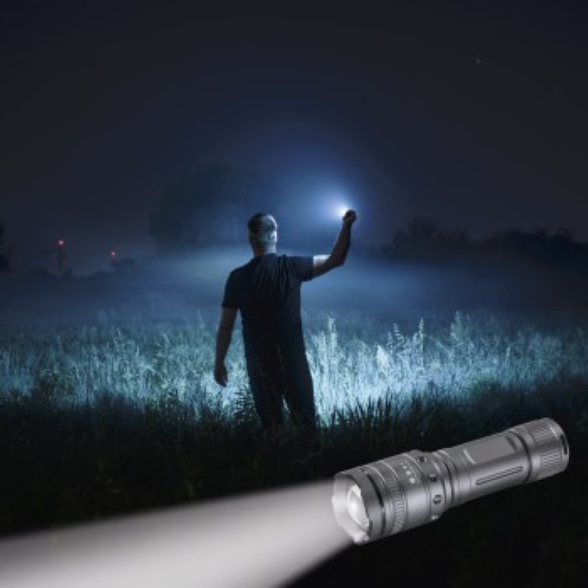 Uomo con torcia illumina campo nebbioso notturno. Torcia in primo piano.
