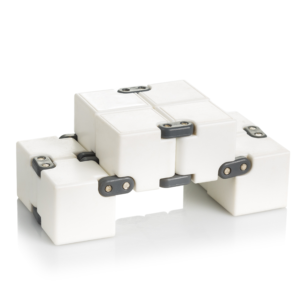 Un cubo infinito de plástico blanco con juntas grises sobre fondo blanco.