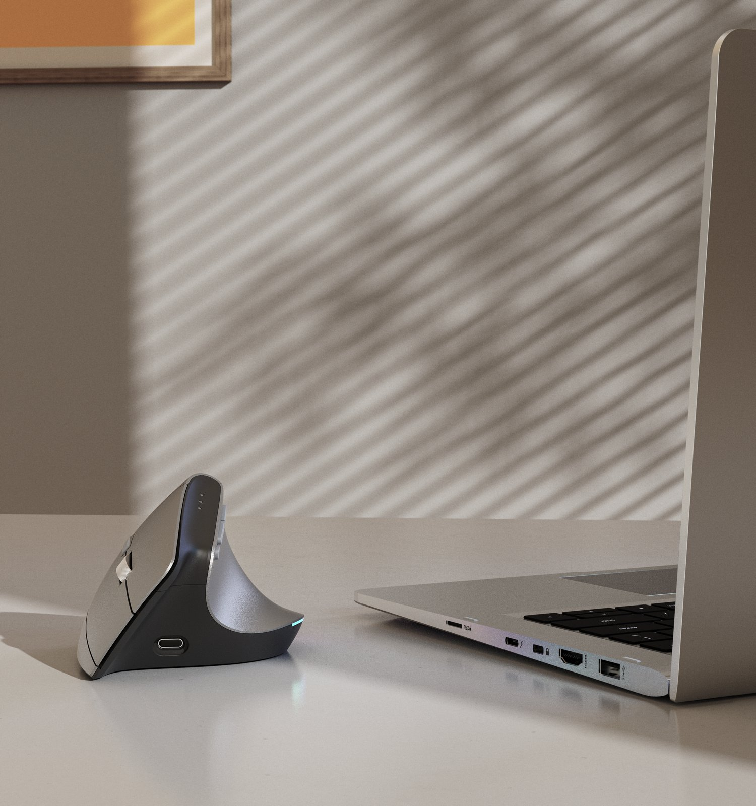 Pionowa mysz i laptop na biurku.