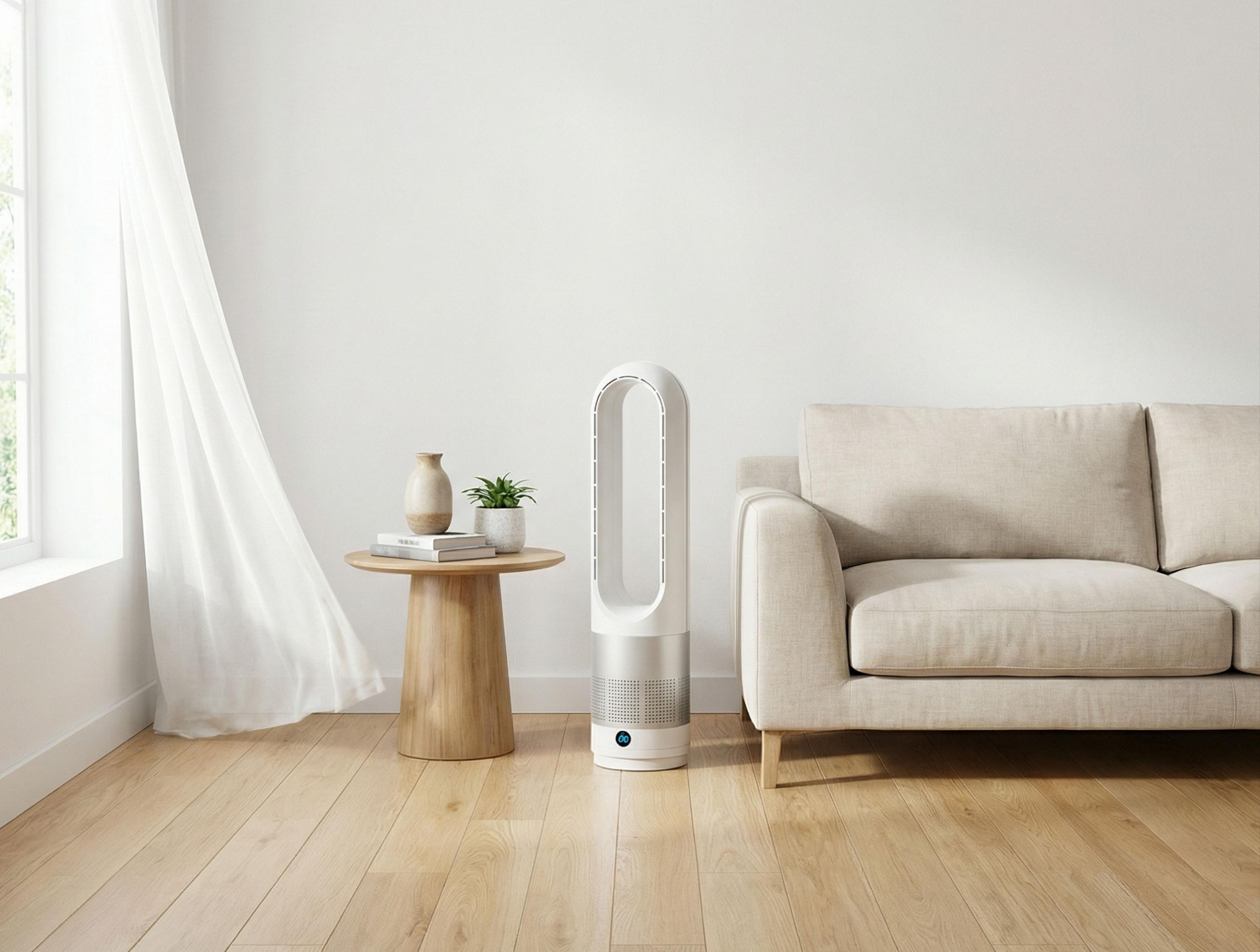 Un ventilador blanco sin aspas junto a un sofá beige sobre suelo de madera.