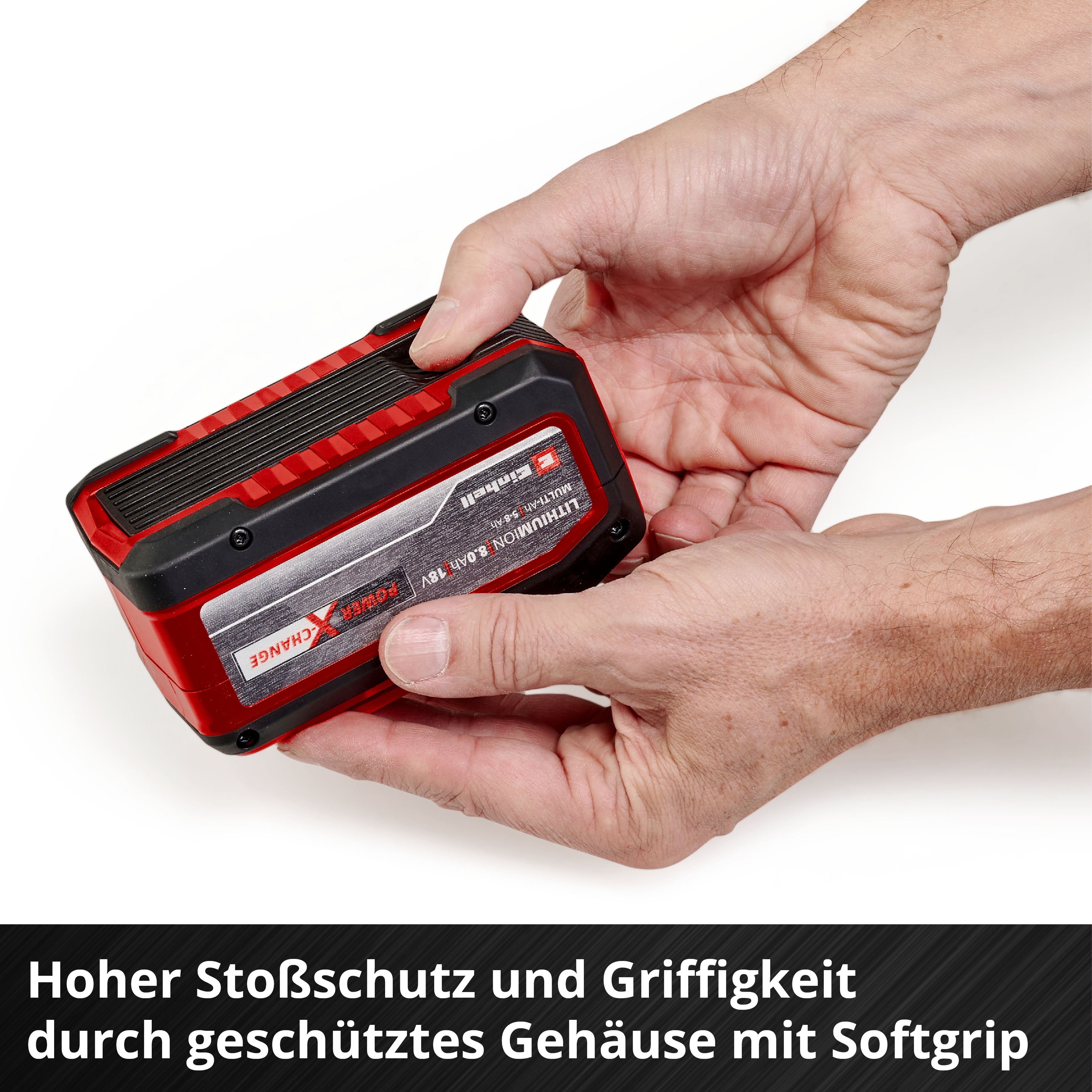 Hände halten einen roten und schwarzen Akku mit Softgrip-Gehäuse.