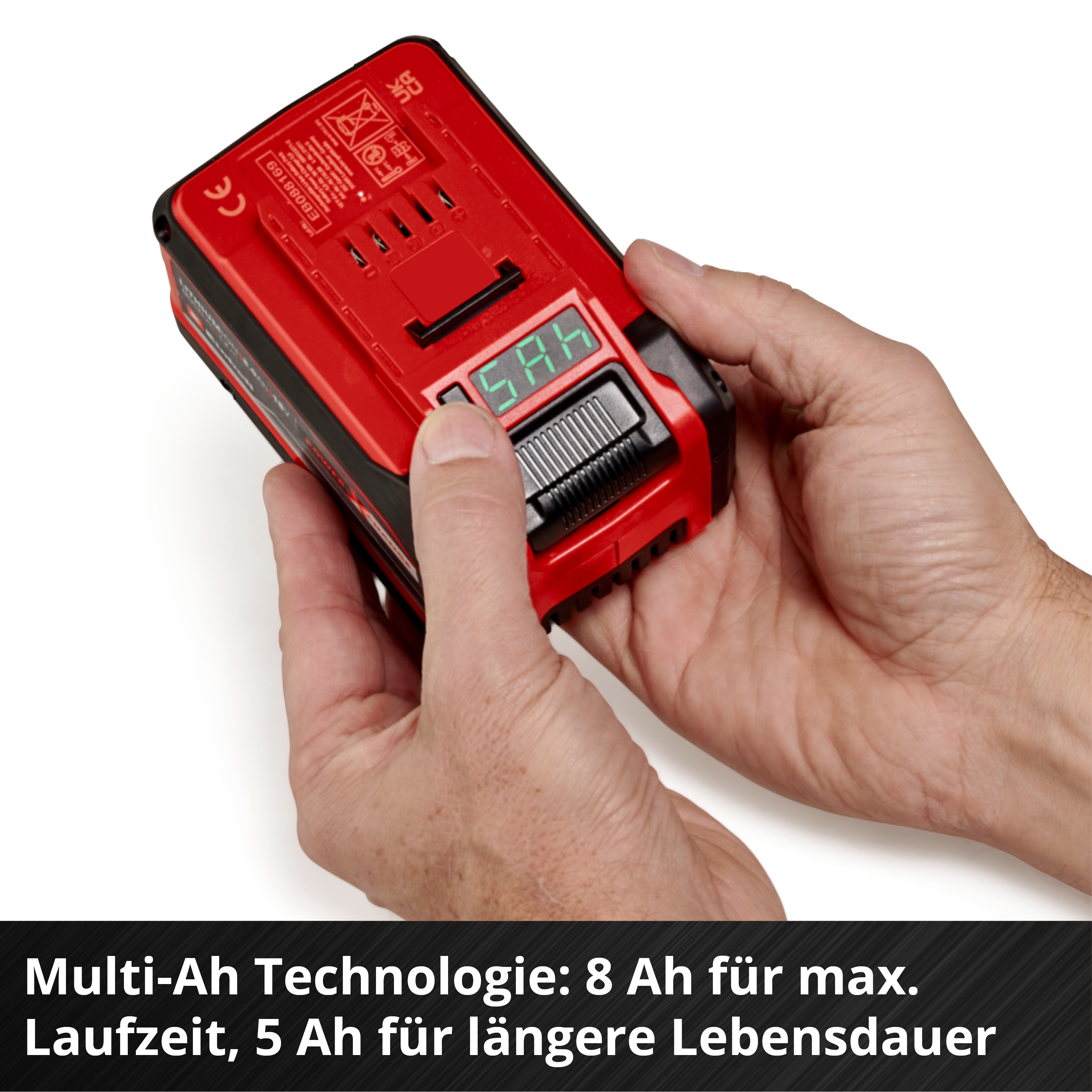 Hände halten roten Akku mit Anzeige. Nahaufnahme.