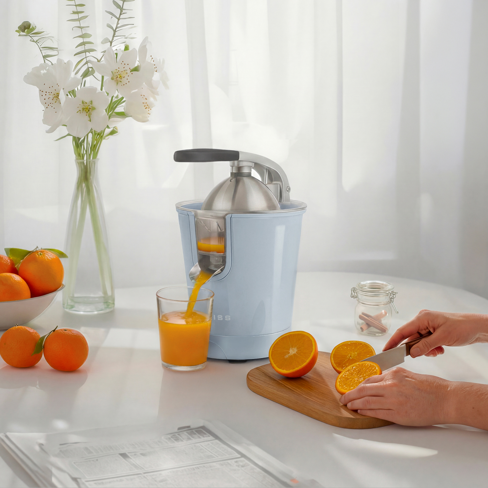 Un spremiagrumi blu estrae succo dalle arance. Arance e un bicchiere di succo sul tavolo.