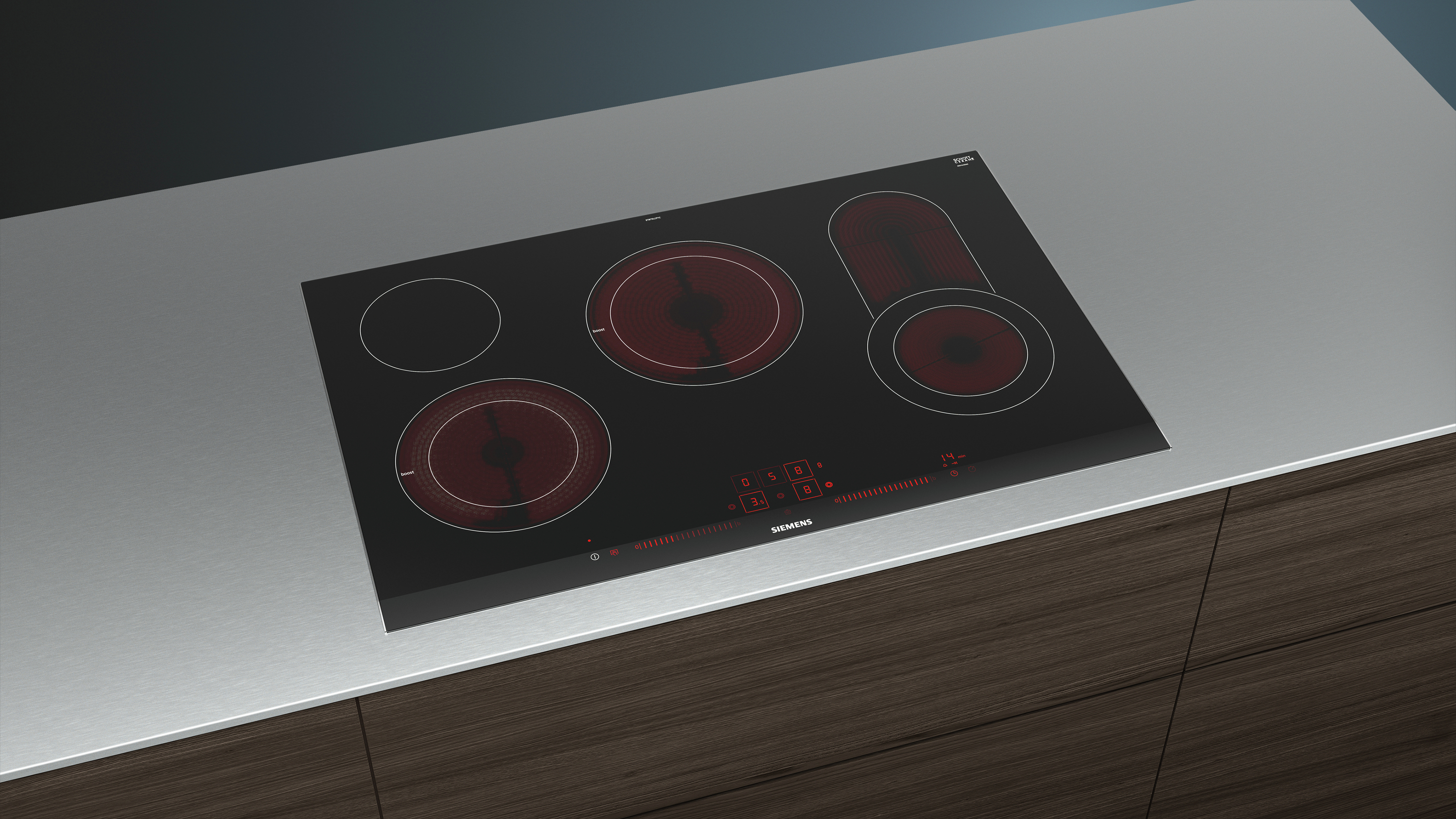 Plaque à induction noire avec quatre zones de cuisson sur un plan de travail.