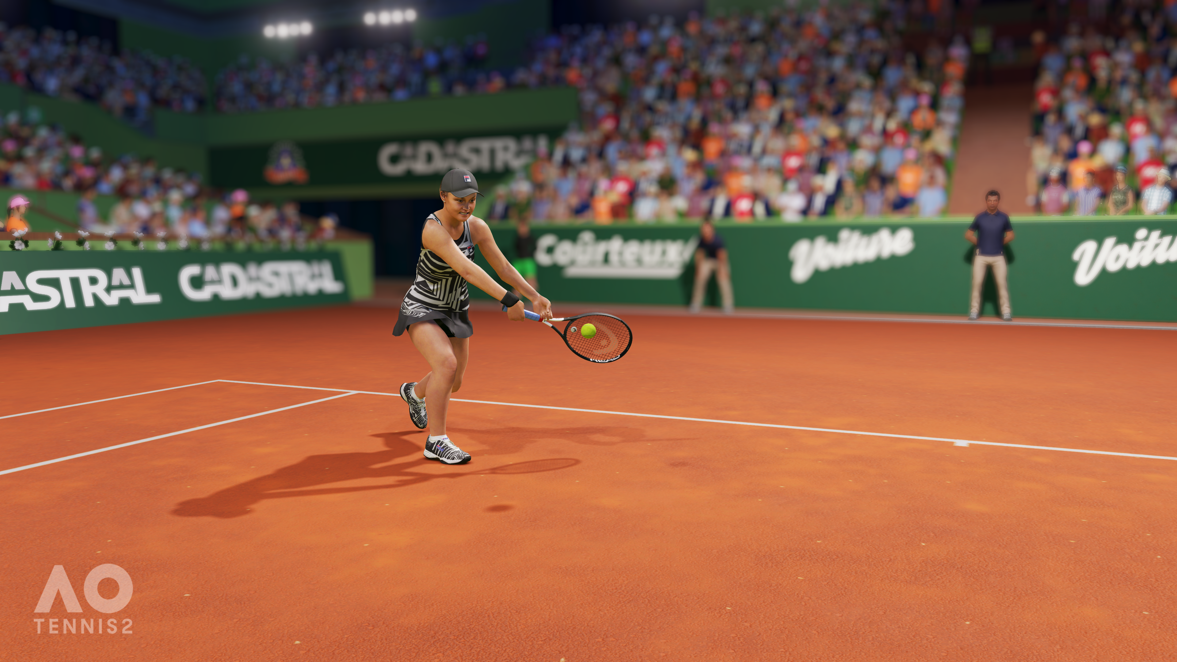 Eine Tennisspielerin schlägt den Ball auf einem Sandplatz vor einem Publikum.