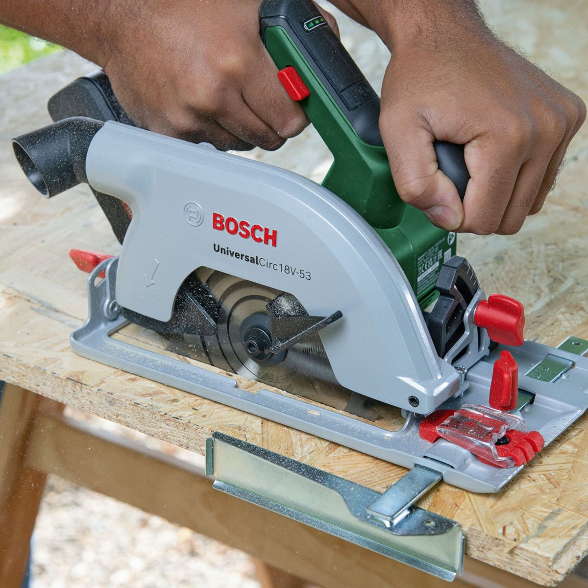 Eine Person benutzt eine Bosch Kreissäge, um Holz zu schneiden.