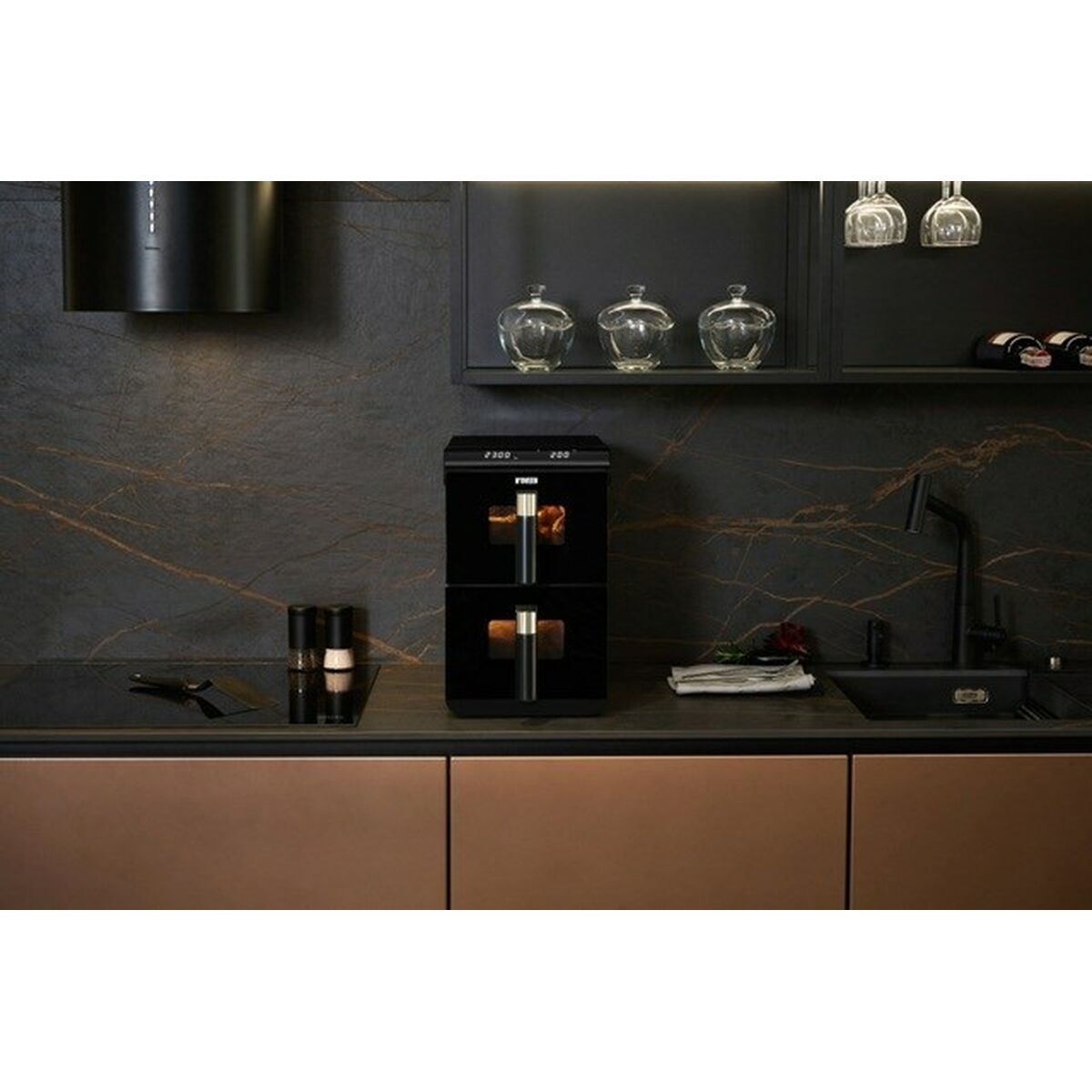 Nowoczesna czarna kuchnia z podwójną frytkownicą powietrzną, ciemnym kamieniem i miedzianymi szafkami.