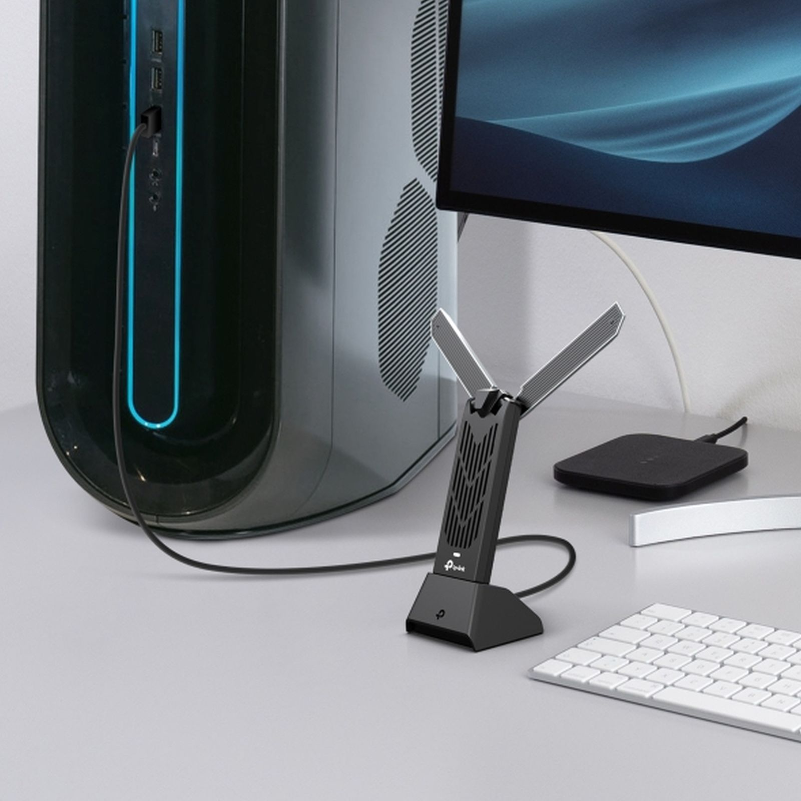 Un adattatore WiFi nero con antenne si trova davanti a un computer.
