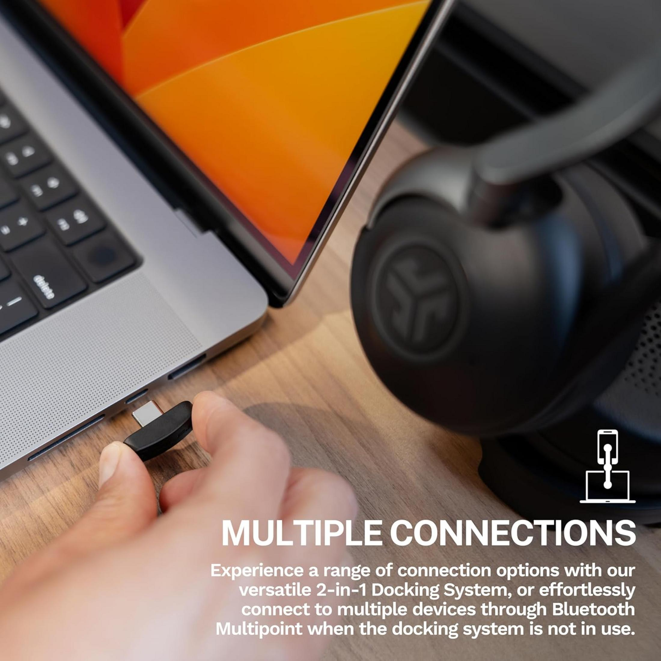 Persona inserisce adattatore USB-C in laptop, cuffie vicine.