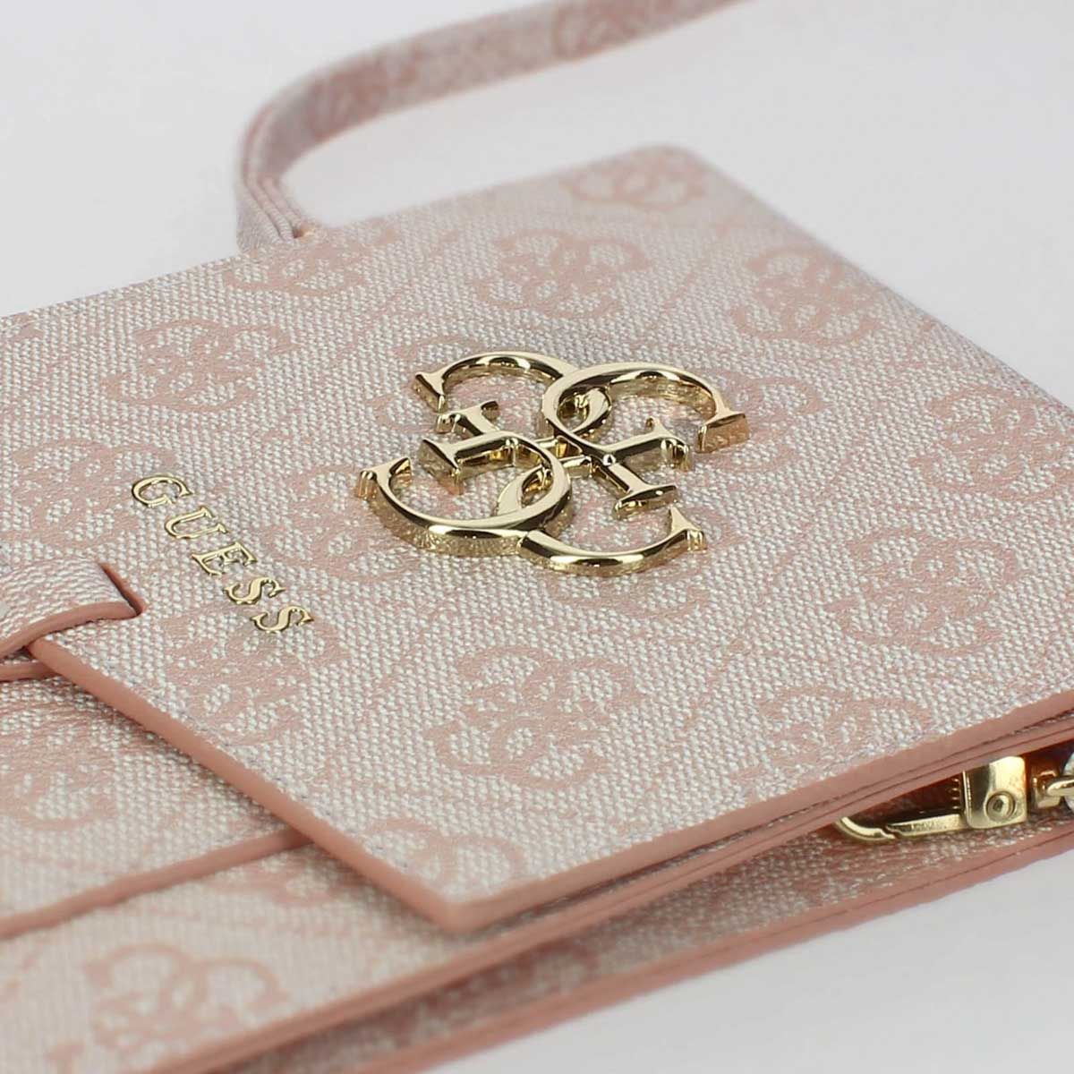Un portafoglio rosa con logo GUESS e fantasia monogramma.