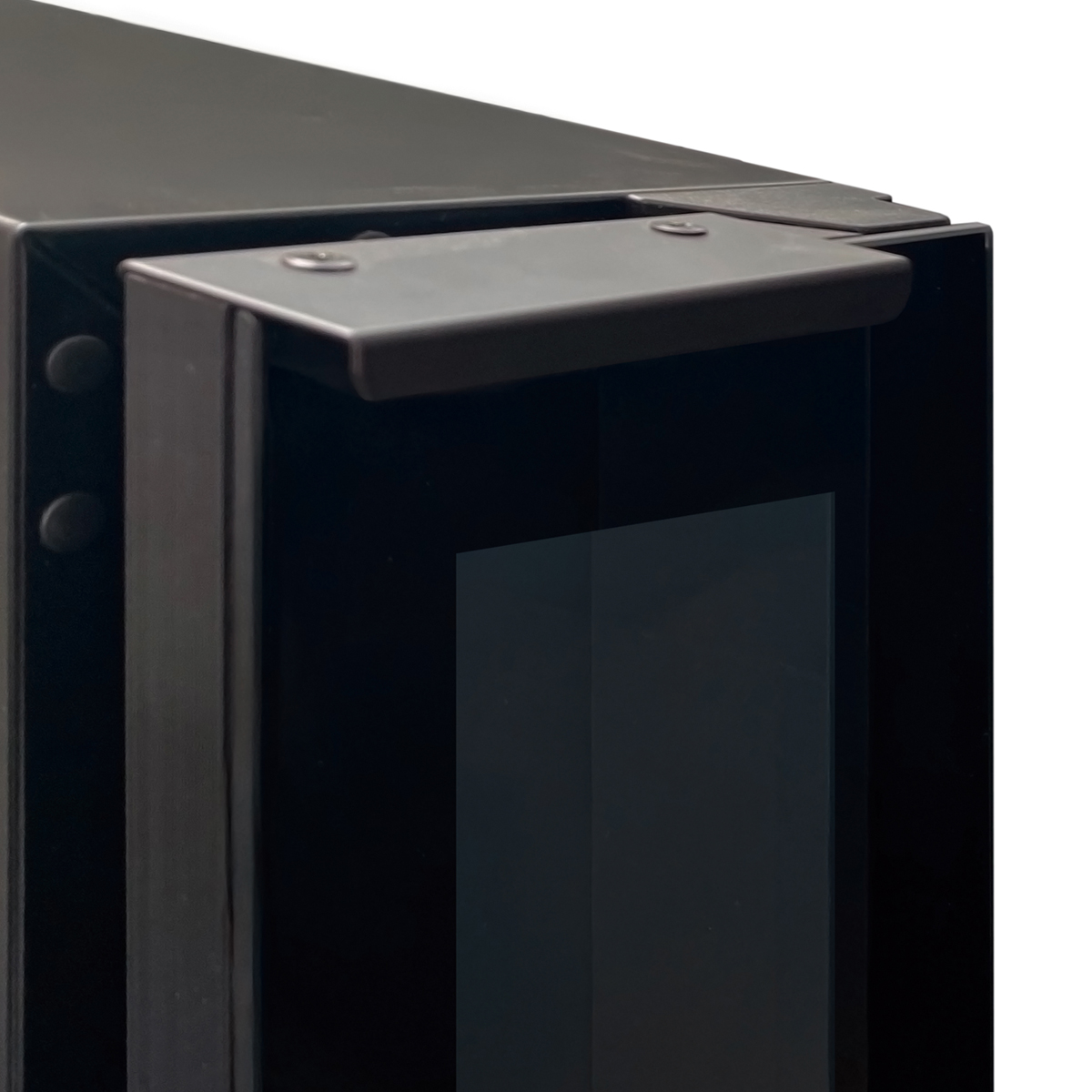 Primer plano de un borde de metal negro con tornillos y una ventana de cristal oscuro.