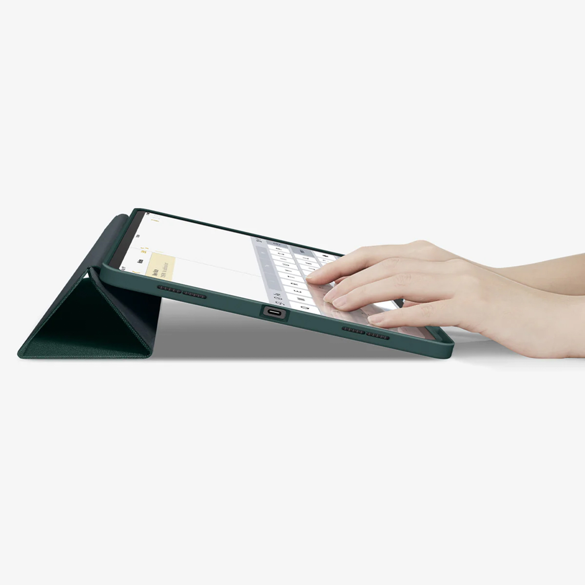 Hands typing on a green tablet with a keyboard case.