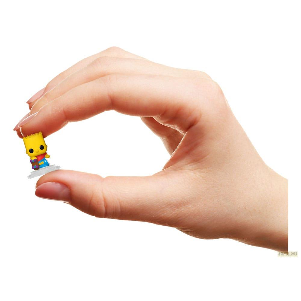 Minuscola figura di Bart Simpson su un piedistallo bianco, tenuta da una mano.