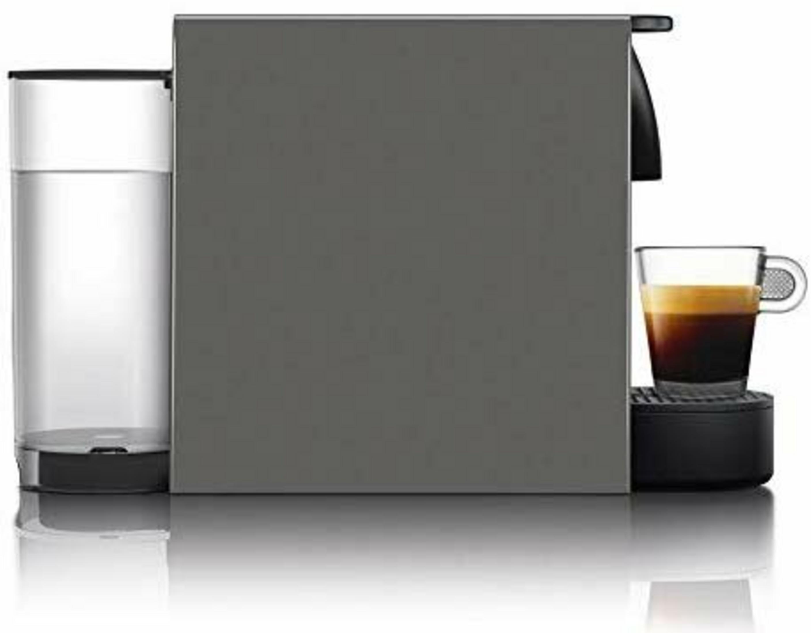 Graue Kaffeemaschine mit Wassertank und Espresso in einem Glas.