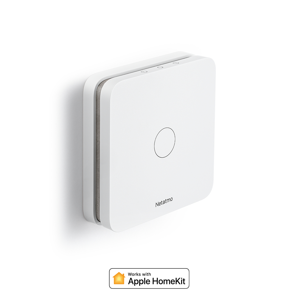 Ein weißes Netatmo-Gerät mit Apple HomeKit-Logo an einer weißen Wand.