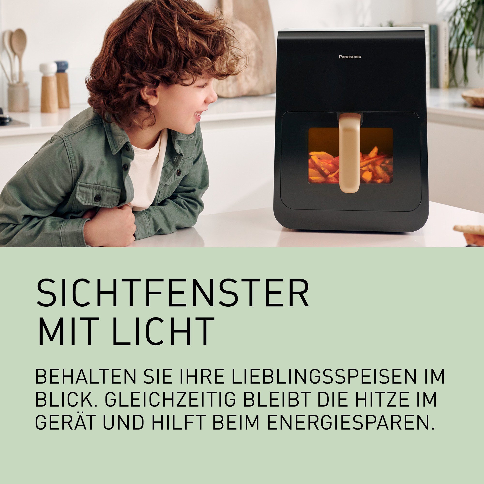 Chłopiec patrzy na czarną frytkownicę beztłuszczową z frytkami w środku.