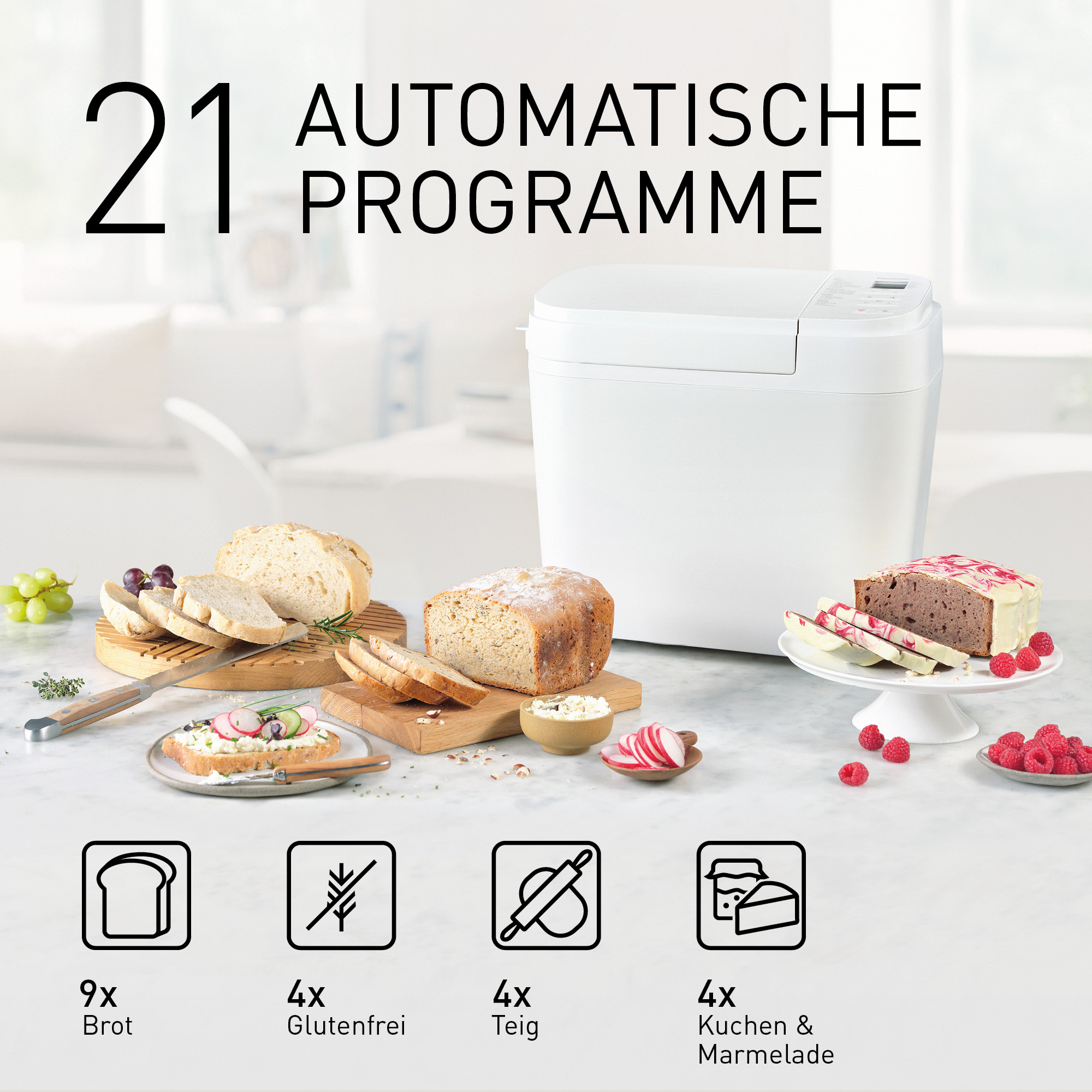 Ein weißer Brotbackautomat mit Brot, Kuchen und Beeren.