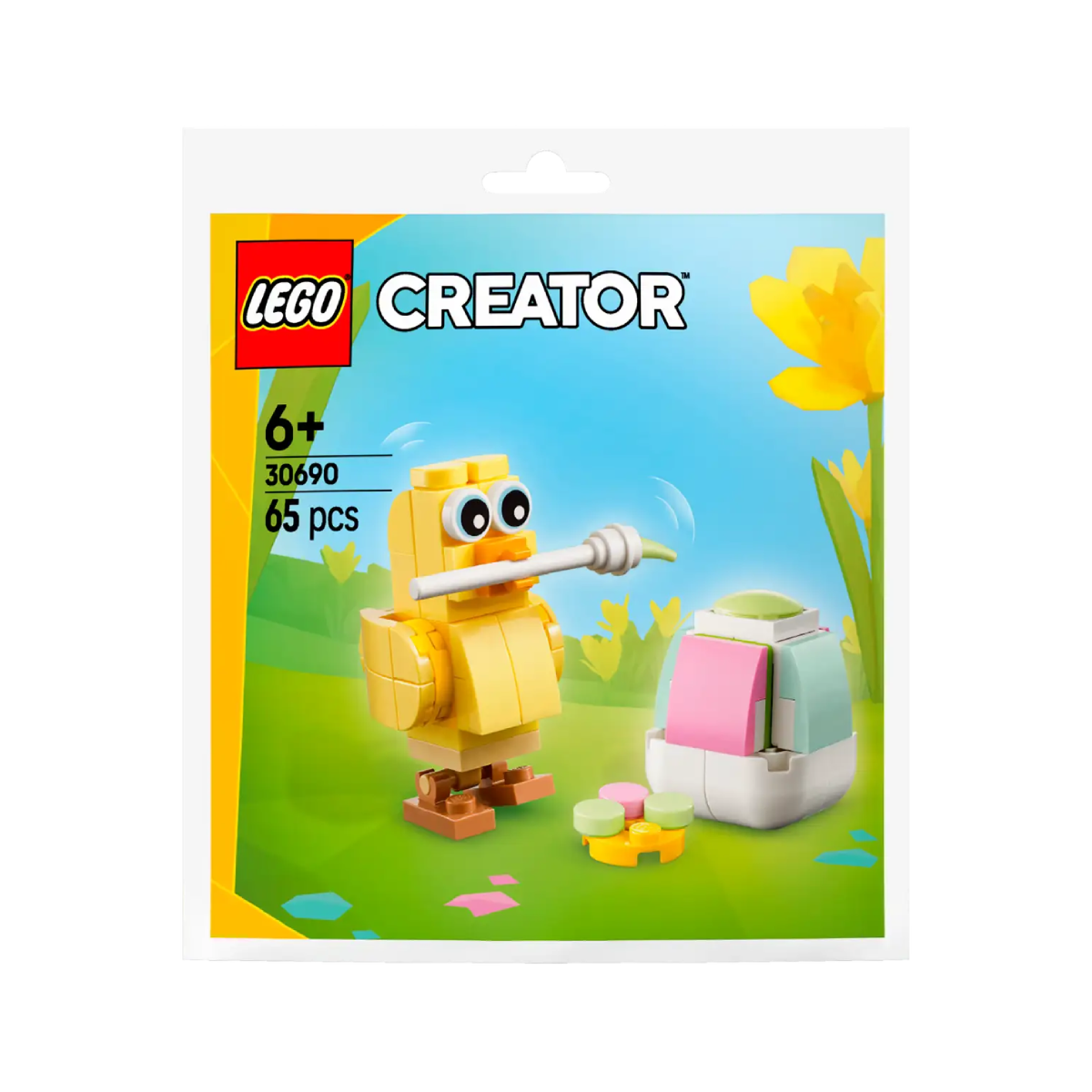 Un pulcino Lego giallo con un bastone davanti a un uovo colorato e fiori.