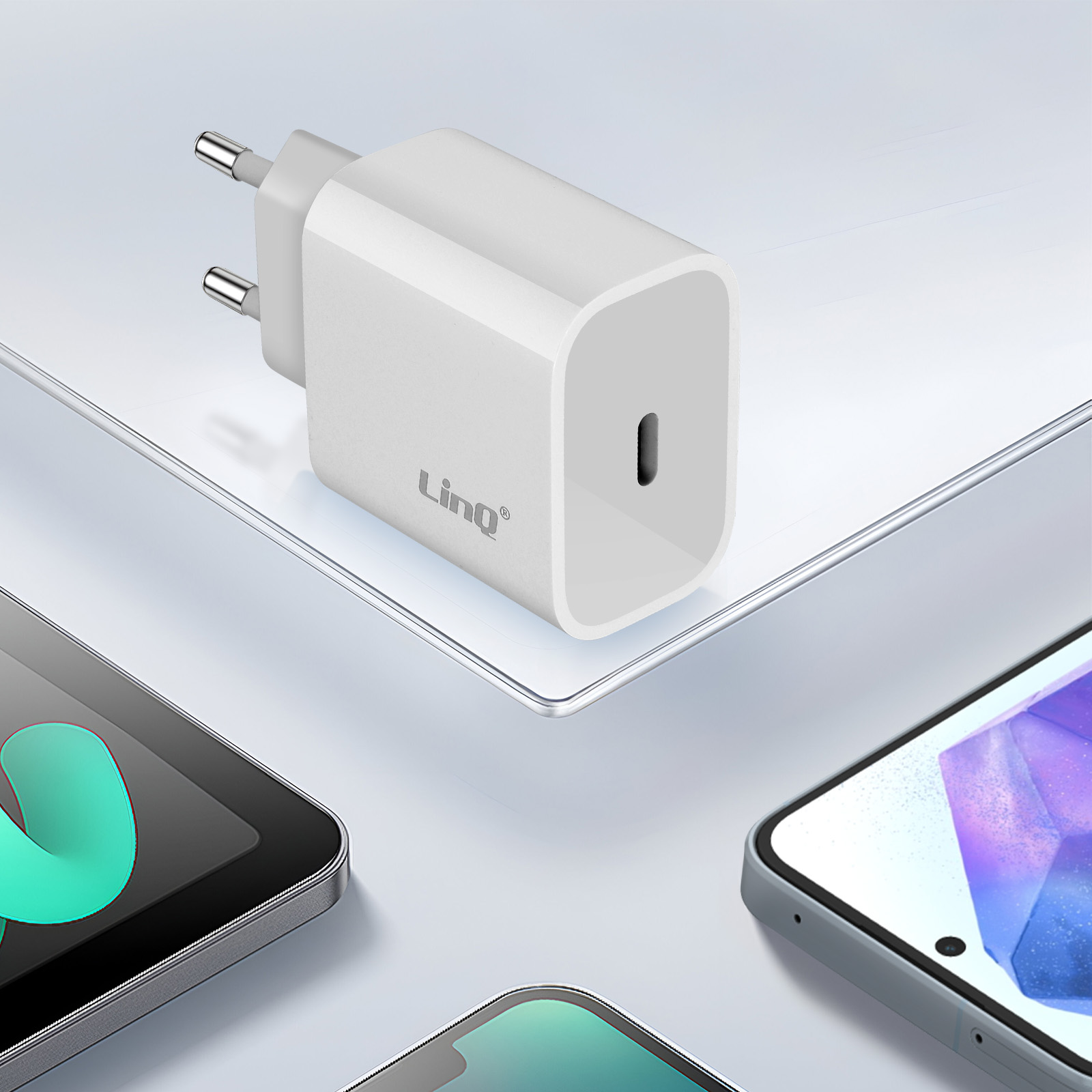 Un adaptateur USB-C blanc avec des broches européennes et deux smartphones.